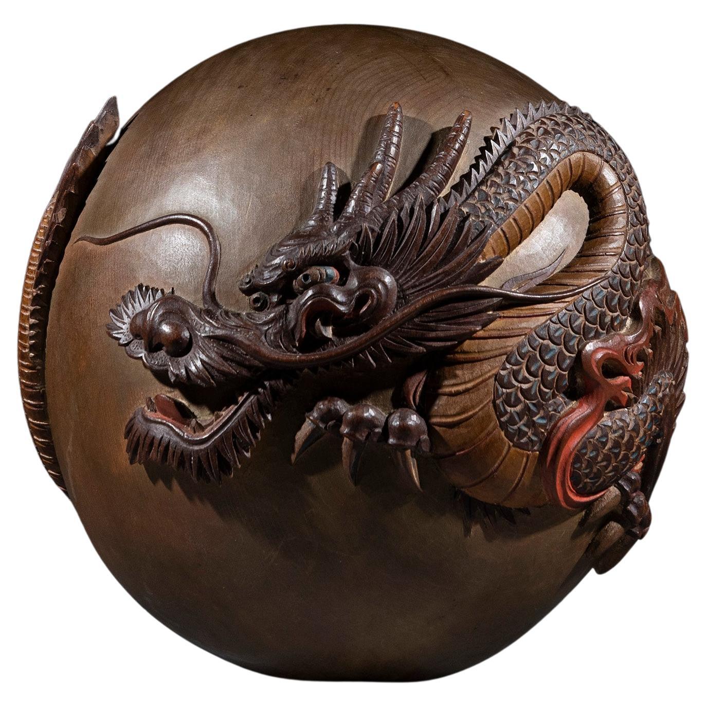 A wooden sculpture in the form of a sphere with a dragon carved in the round For Sale