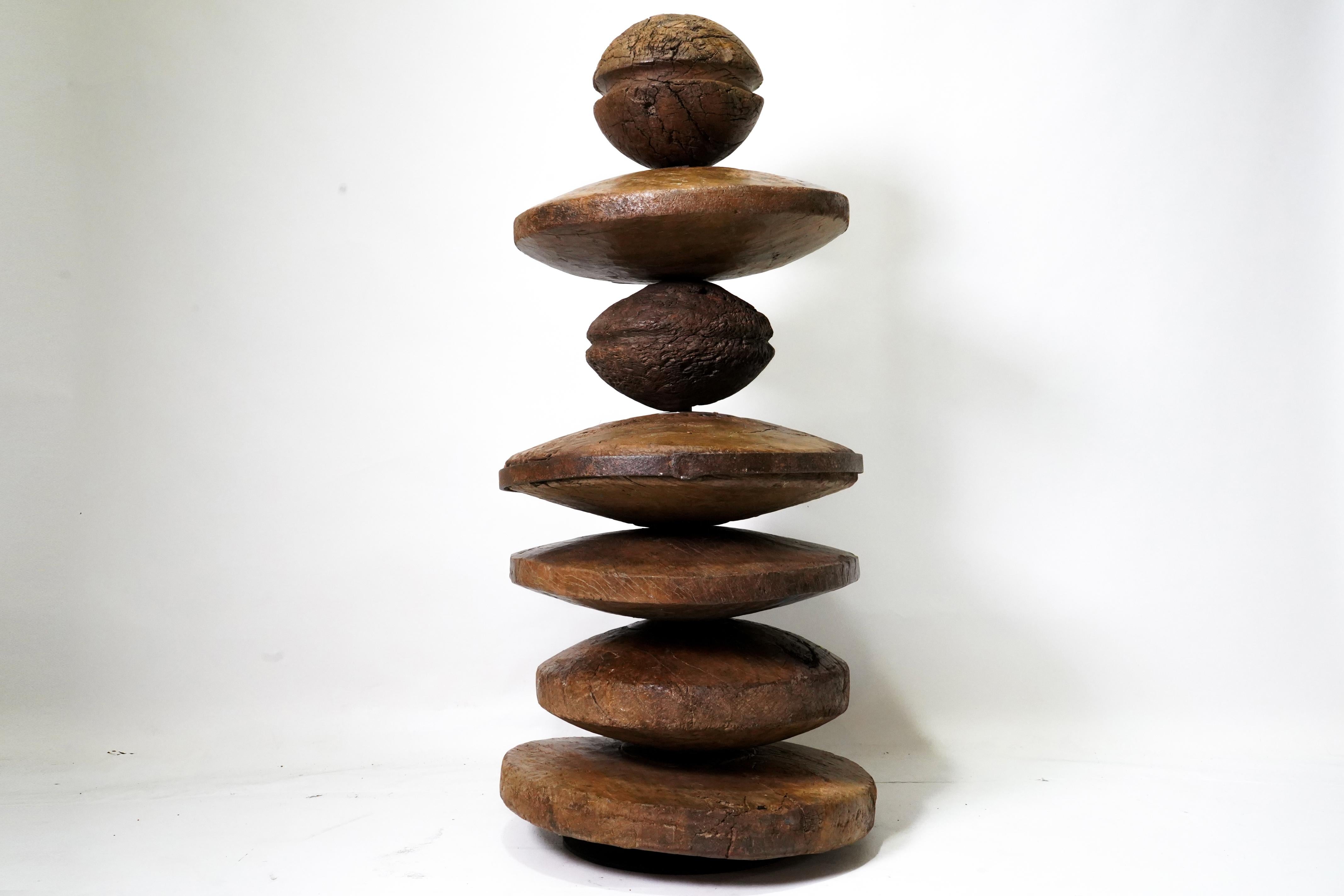 This stunning sculpture makes a powerful statement in any contemporary home.  The artwork is made up of a curated collection of antique Indian cart wheels and wooden pulleys, once used in textile looms.   The various parts have been assembled to a