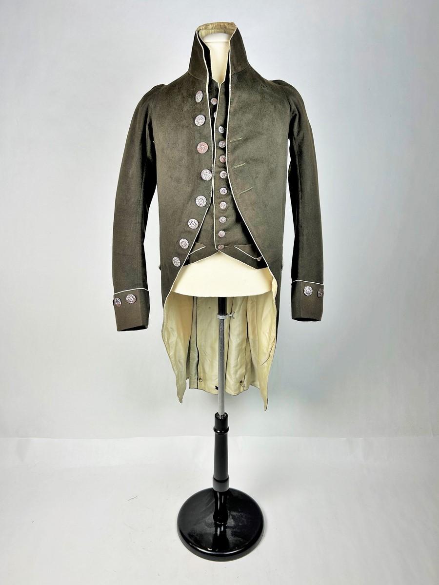 Circa 1805
France Premier Empire period

Frockcoat and waistcoat in brown wool complete with its chased steel buttons from a famous family of the French Premier Empire. Suit with tail, high collar, bent sleeves and lapel cuffs, complete with