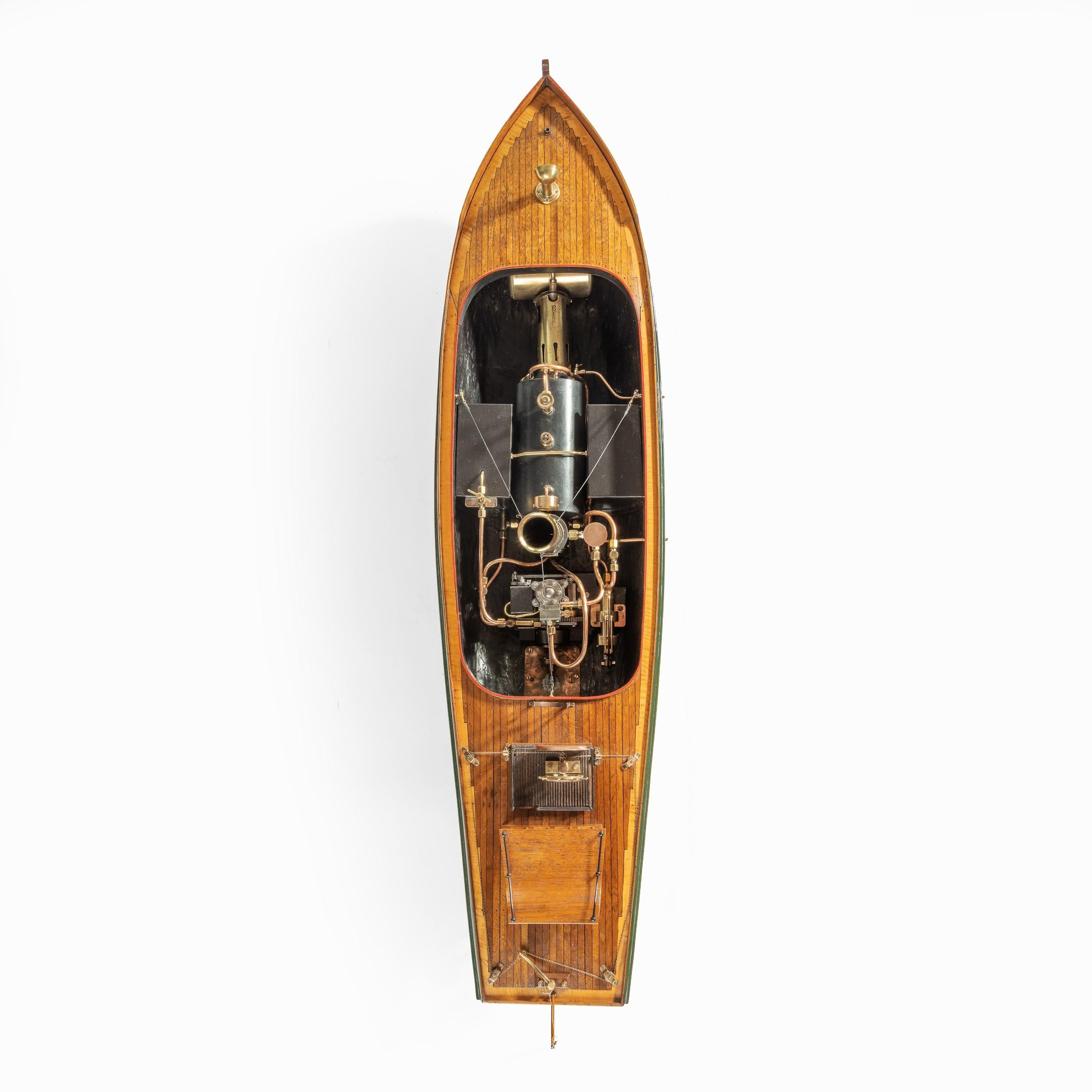 This owner’s model of a steam launch is painted with green topsides and a red bottom, and has planked and pinned mahogany decks with fiddleback maple thwarts. The decks have many authentic details including a mahogany coach house and brass funnel.