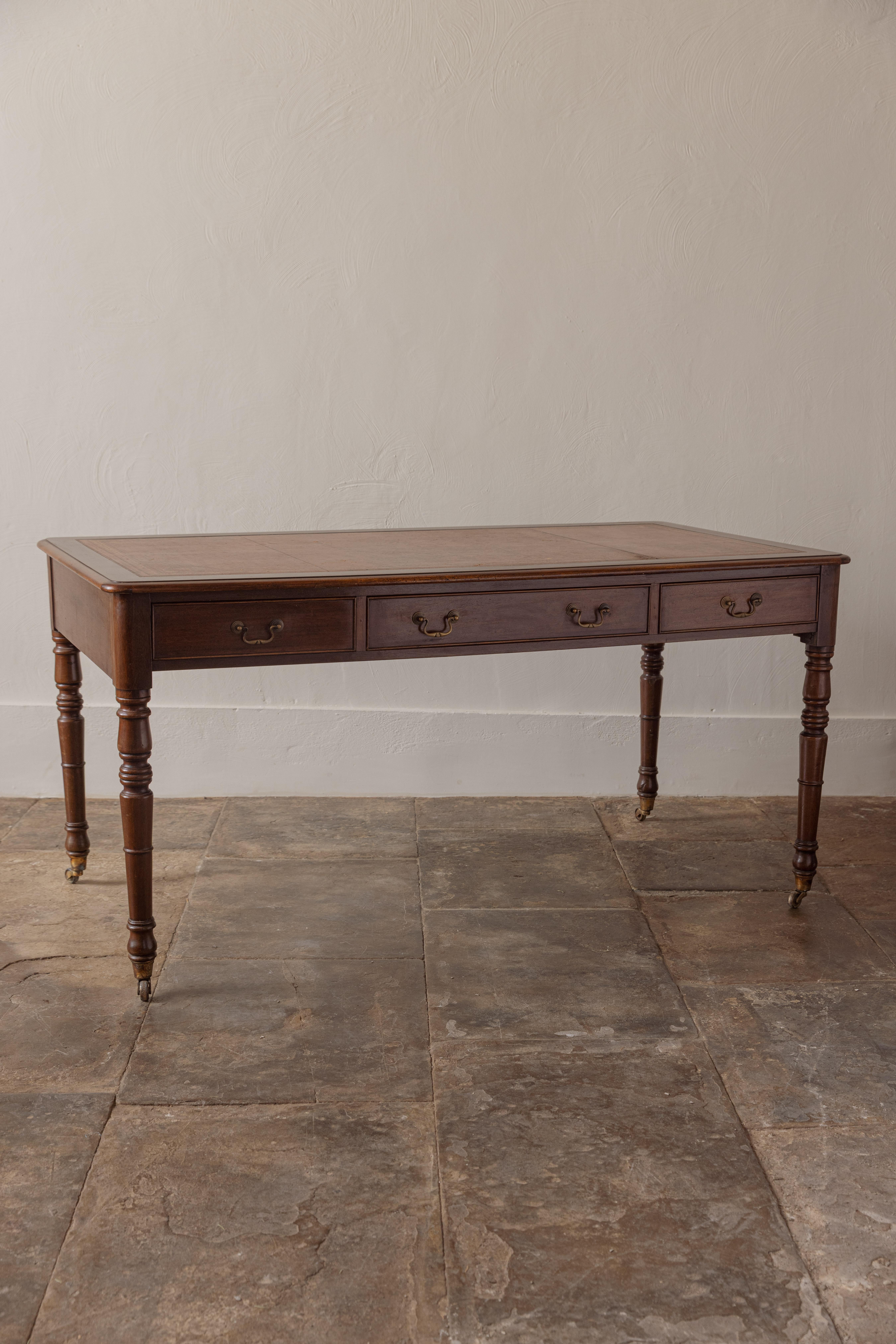 Une belle table à écrire à trois tiroirs en acajou avec un plateau en cuir au-dessus de pieds tournés sur des pieds à roulettes. Des proportions élégantes.

Le dessus en cuir marron est en bon état, sans déchirure.

Angleterre, début des années 1900