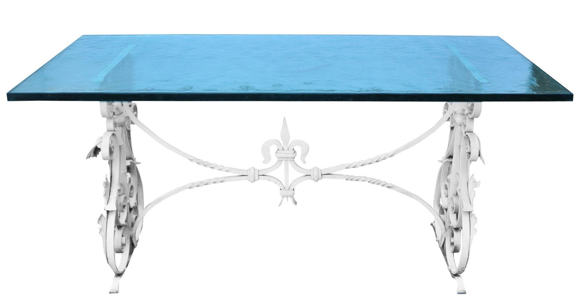 A blacksmith made wrought iron frame with a textured glass table top. The table top and frame come apart for transport.