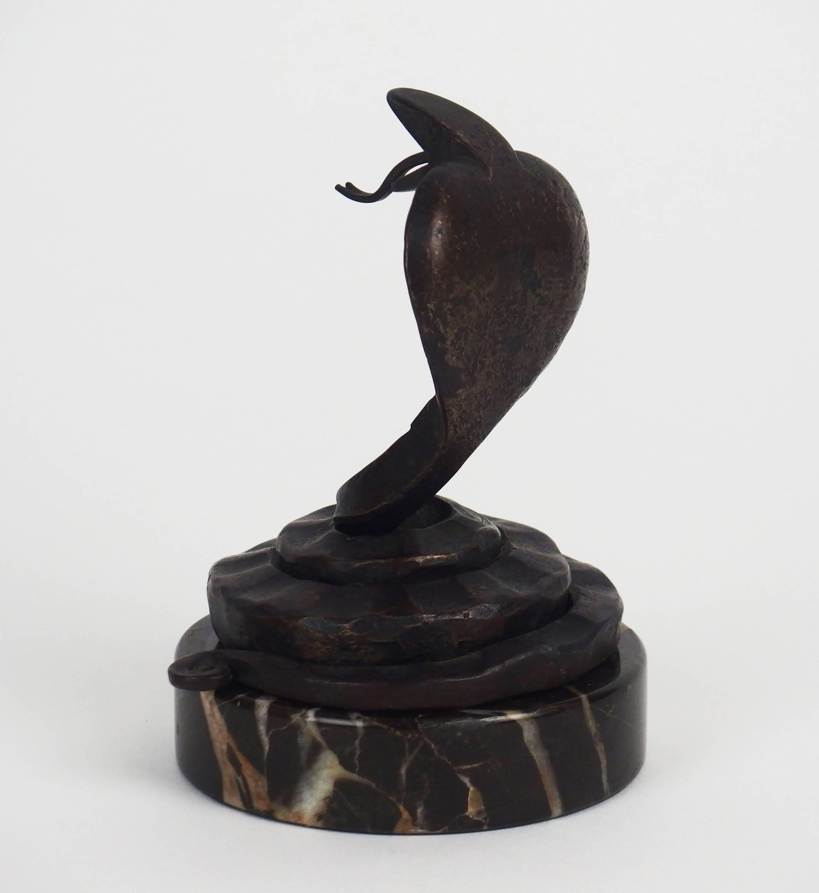 A wrought iron coiled up cobra on a black marble base. Stamped by the artist on the lower coil.
Measures: height without marble base: 4.5in.