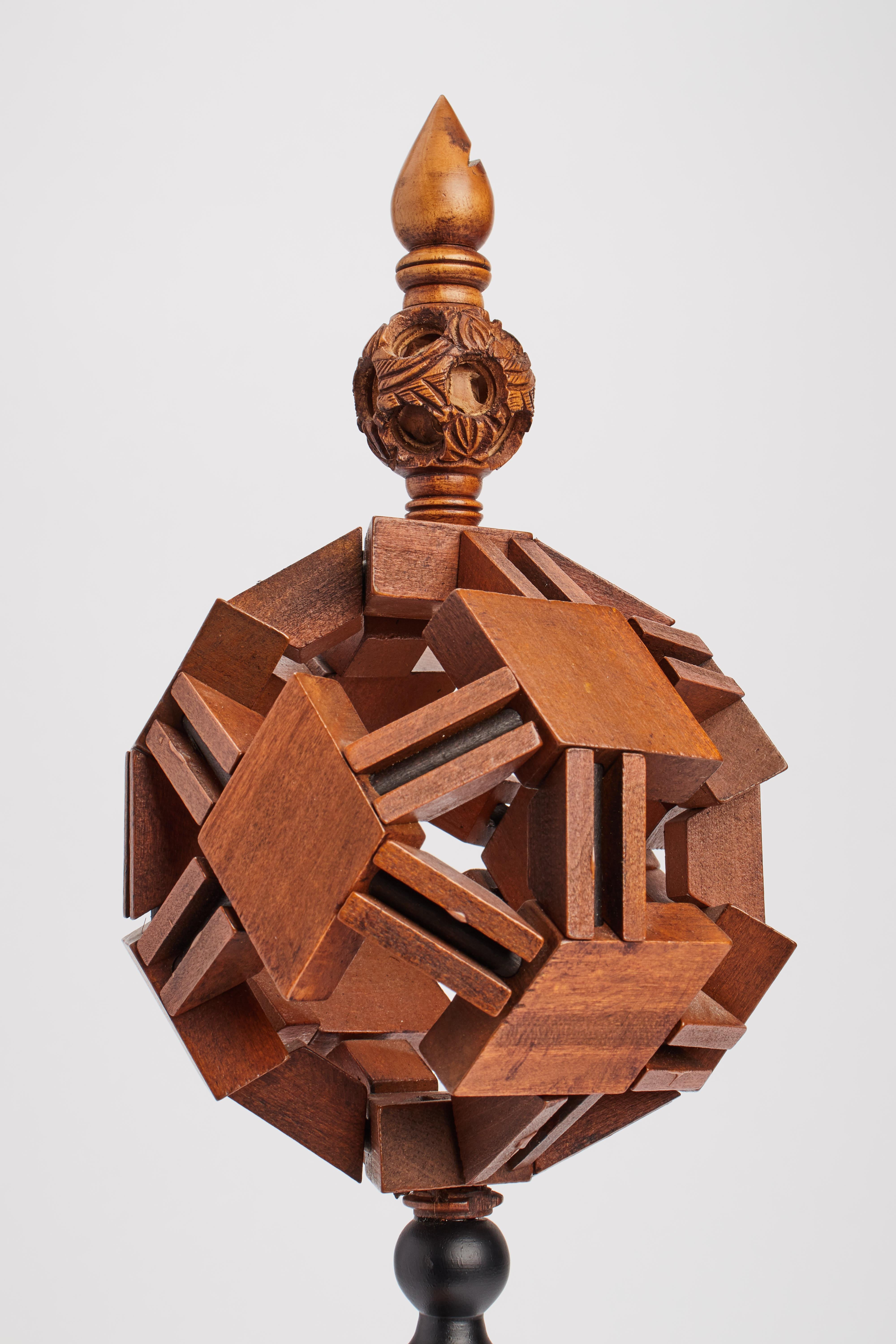 Geometrisches Modell. Der Sockel aus Obstholz ist schwarz gebeizt (ebanisiertes Holz), darüber befindet sich eine Kugel aus geometrischen Eichenholzelementen. Insgesamt eine weitere kleinere Kugel. Deutschland 1880 ca.