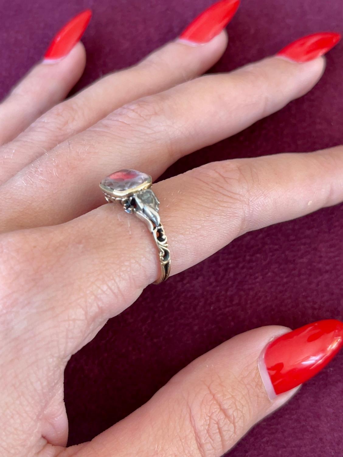A wonderful Georgian ring which is composed of a large Paste and Old European cut Diamonds on either side full of the grace and splendor of a bygone age.
The central stone is encased in a Red tin foil, which gives it the reddish/pink color,

The 18k