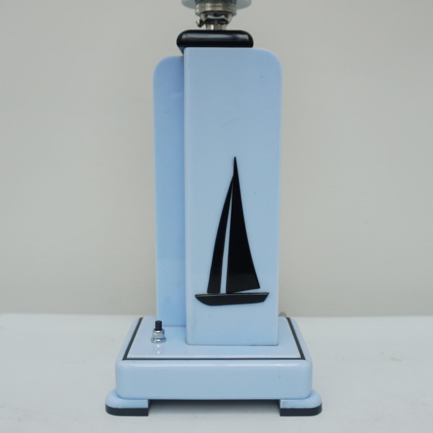 A Yachtsman's table lamp. Blue and black acrylic with a sailing yacht depicted in the stem. Chromed metal with a white glass globe shade. 

Dimensions: H 52cm W 16cm D 11cm 

Origin: English

Item Number: J241

All of our lighting is fully