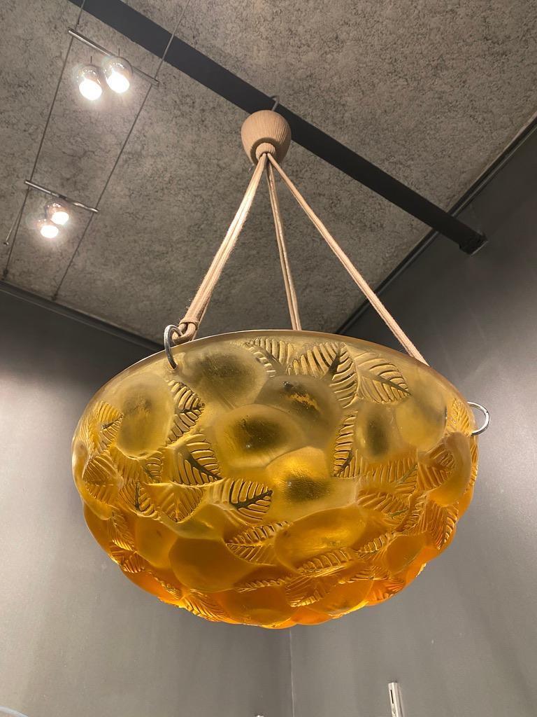 A glass Lausanne Chandelier by R.Lalique made in 1929.

This piece is in yellow glass and in perfect condition.

The electricity has been redone.

The total height is 70 cm including the ropes.

The glass part is 38 cm wide and 15 cm