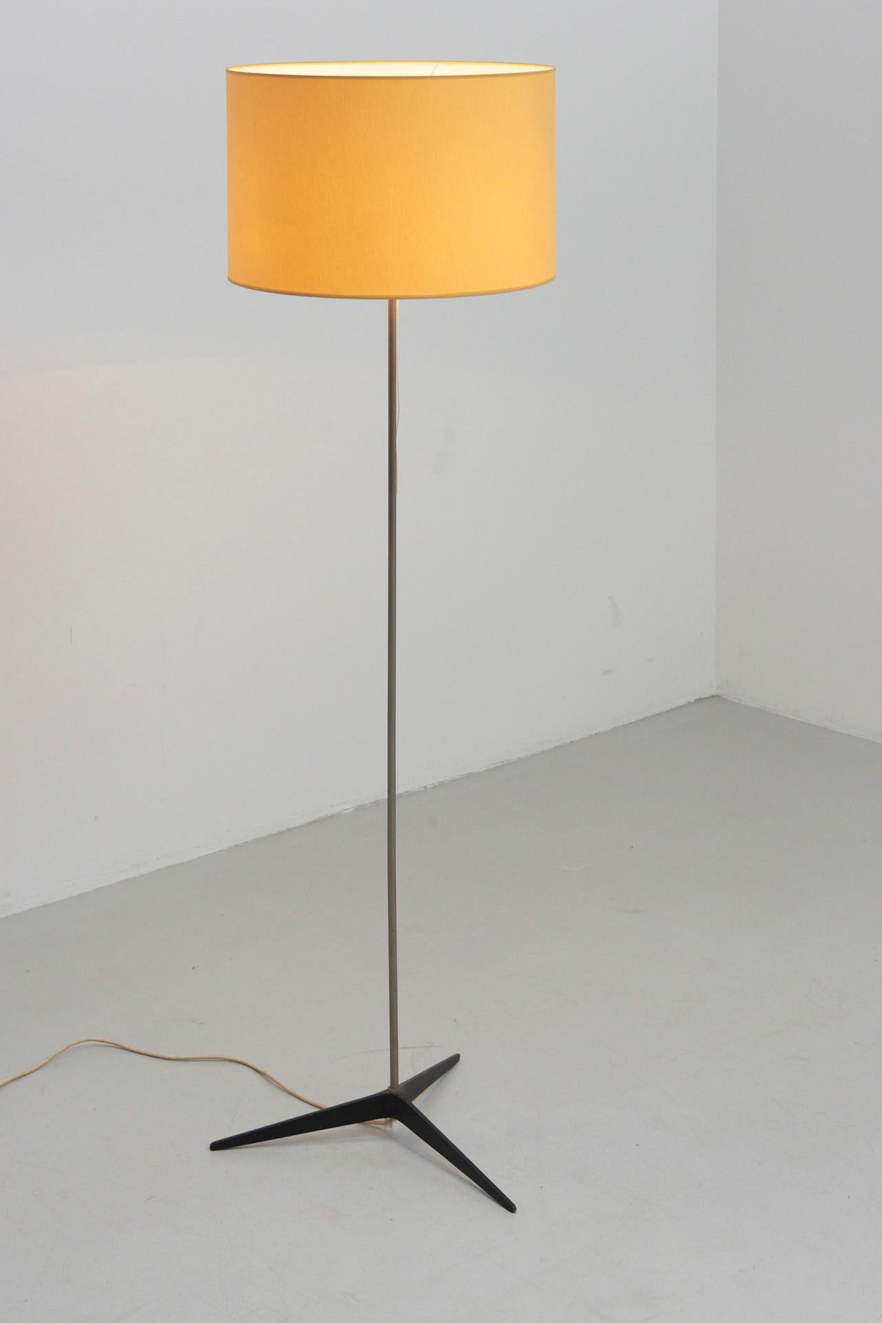 A floor lamp with 3-star foot in black steel and original yellow lampshade. Holds 2 bulbs (E27).