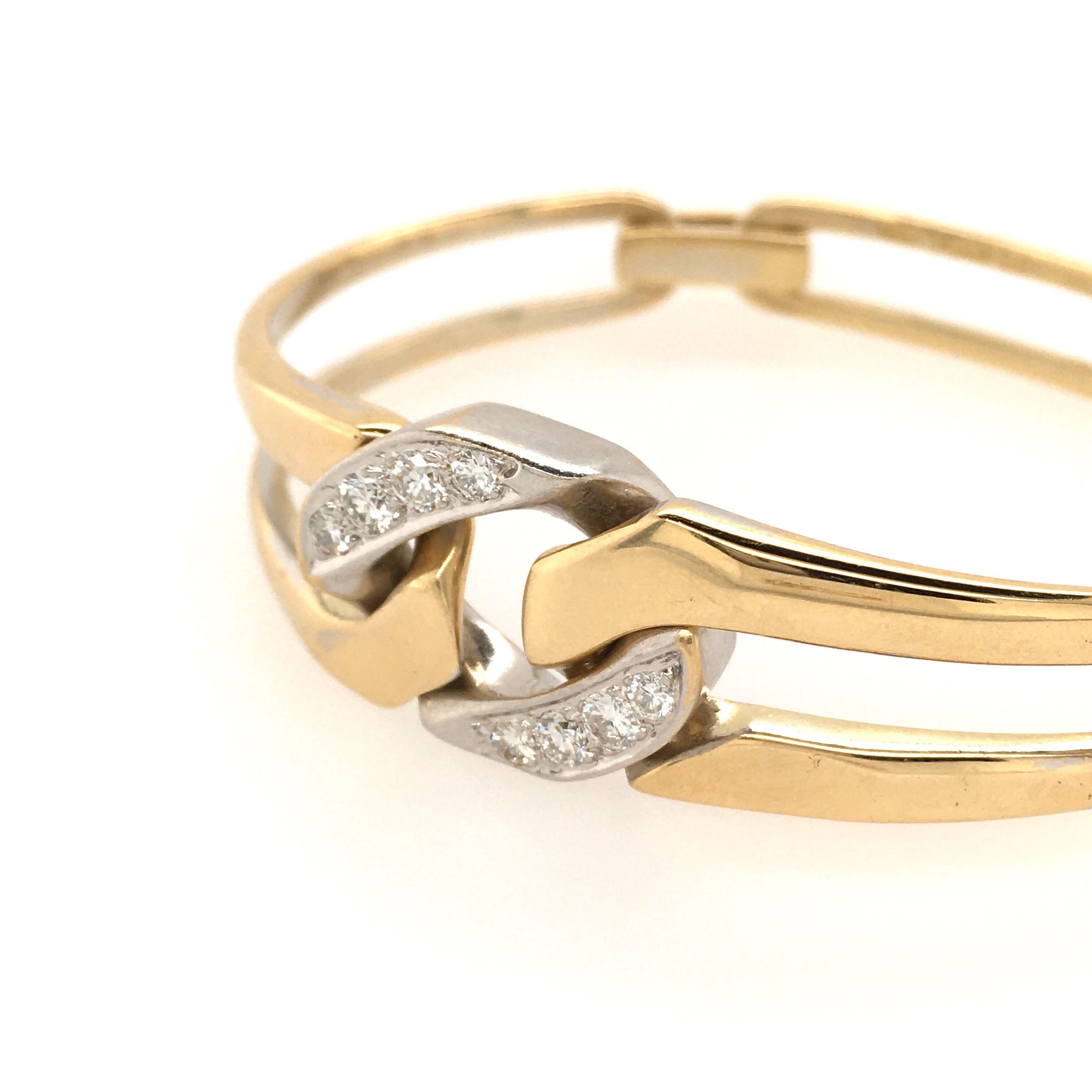 An 18 karat yellow gold and diamond bracelet. Italian. Designed as a tapering polished openwork bangle, set to the top with a pave set diamond curb link. Width is approximately 5/8 inches at widest, gross weight is approximately 32.2 grams. 