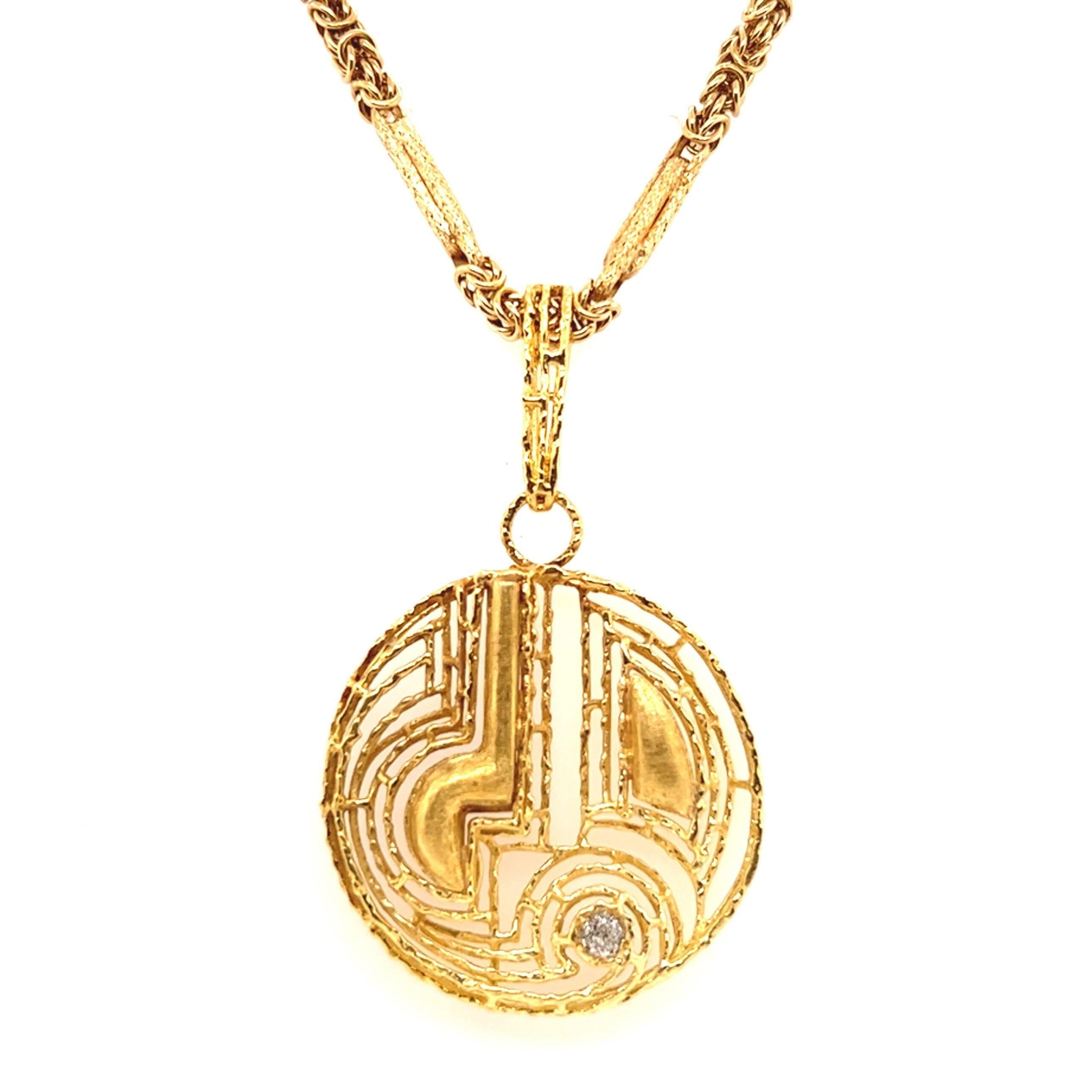 A 15 karat and 18 karat yellow gold and diamond pendant necklace, pendant circa 1970.  The 18 karat yellow gold chain comprised of textured quadruple bar links alternating with lengths of Byzantine chain suspending a round abstract openwork pendant