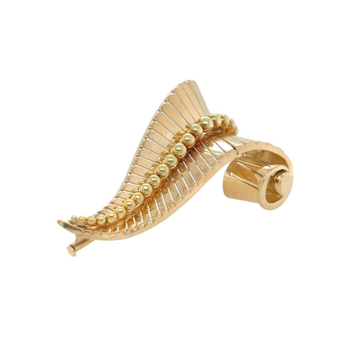 A 14 karat yellow gold brooch, circa 1940s.  Designed as a scrolling tapered horizontally striated motif applied with a graduated row of gold beadwork down the center.  Length approximately 2 5/8 inches.  Gross weight approximately 22.20 grams.