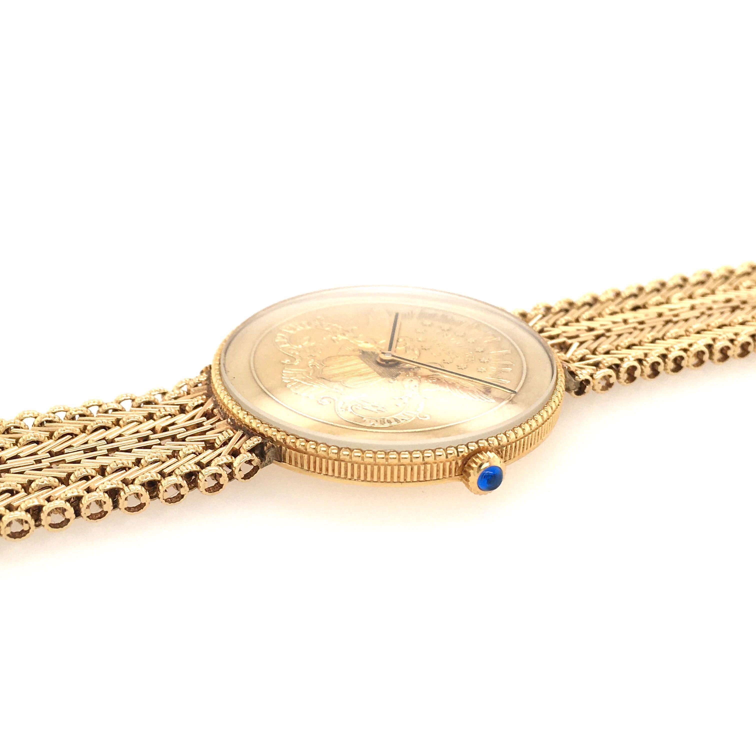 An 18 karat yellow gold watch with 22K karat gold US coin dial a 14 karat yellow gold bracelet.  Of mechanical movement. 32mm, with textured gold bezel and blued stone set crown. Length is approximately 7 inches (adjustable), gross weight is