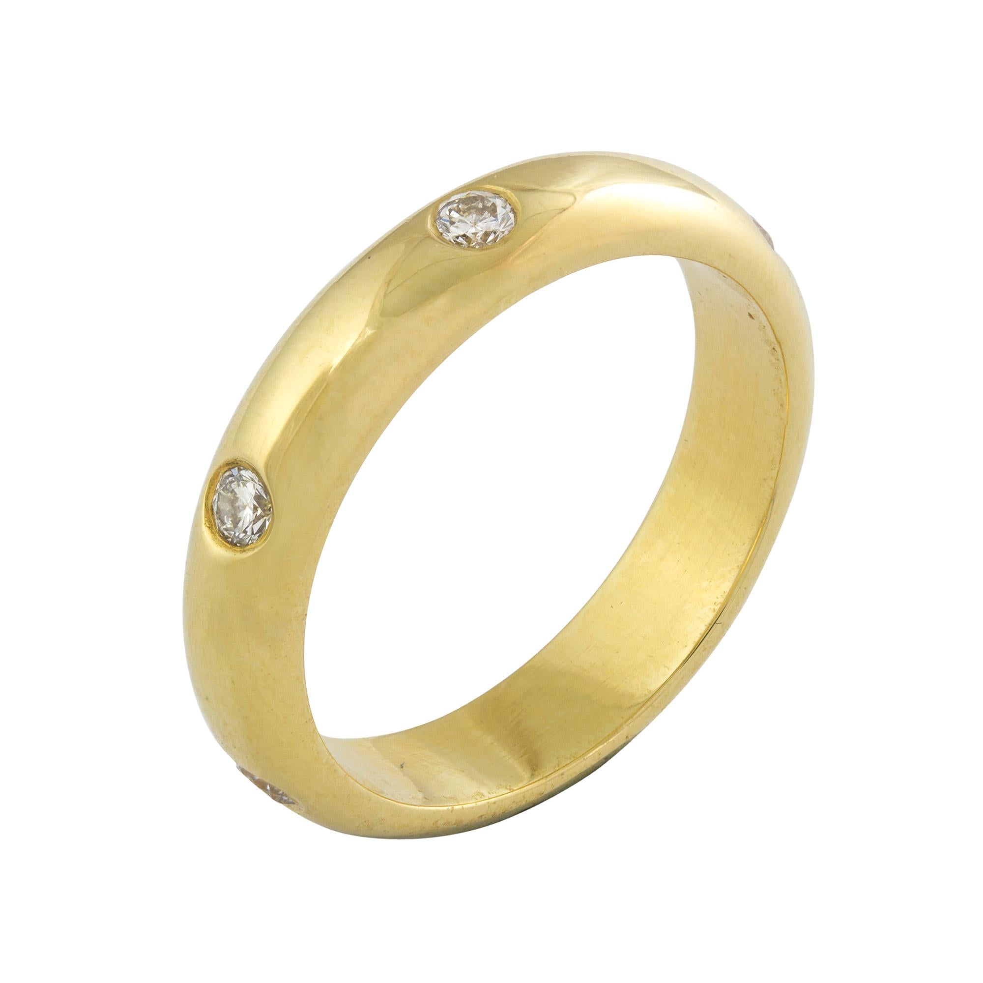 A diamond set wedding band, the yellow gold D-shape band set at intervals with six round brilliant-cut diamonds, weighing a total of 0.36 carats, hallmarked 18 carat gold, London 2003, finger size N, gross weight 6 grams.

This chic gold and diamond