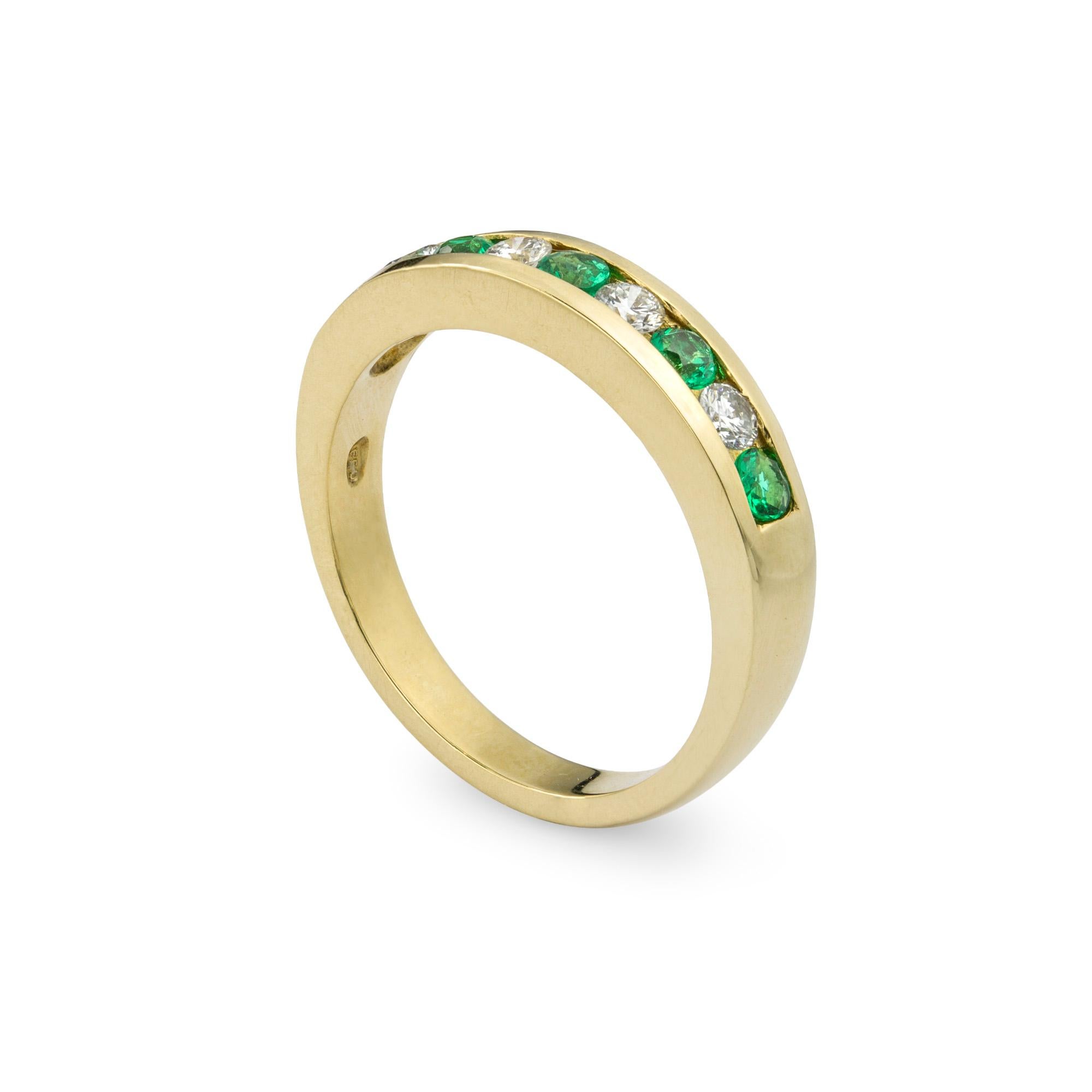 A yellow gold emerald and diamond half eternity ring, with four round brilliant cut diamonds weighing a total  of 0.23cts and five round cut emeralds weighing a total of 0.28cts, all channel set to a yellow gold shank, Hallmarked 750, London 2019,