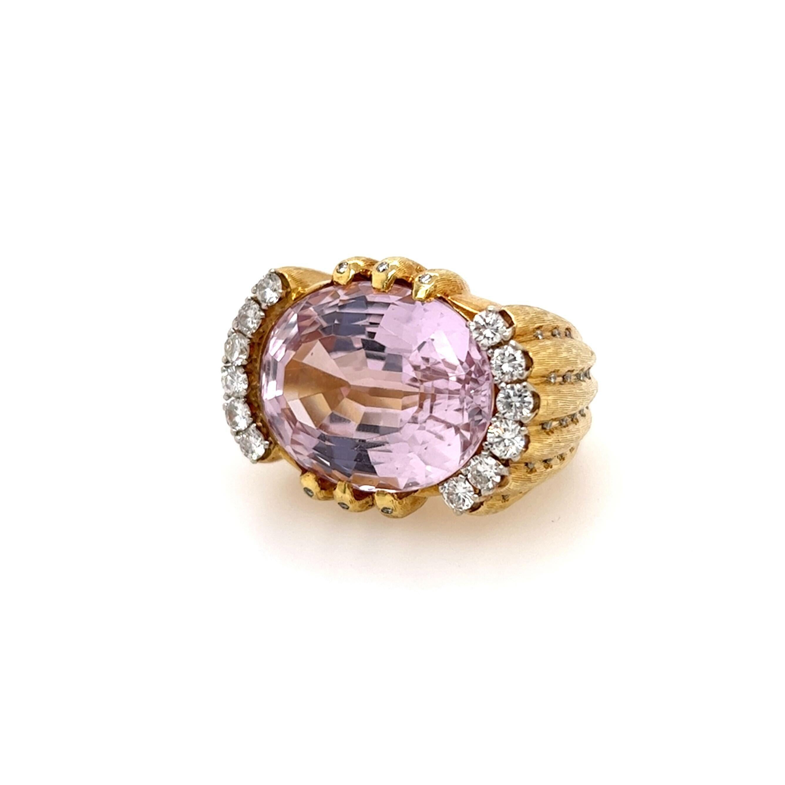 An 18 karat yellow gold, kunzite and diamond ring.  The ring centering a horizontally set mixed cut oval kunzite measuring approximately 23.54 x 17.52 mm. in a raised textured fluted mount, enhanced with twelve (12) brilliant cut diamonds at the