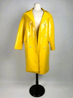 A yellow waterproof coat made of shiny PVC - France, circa 1965