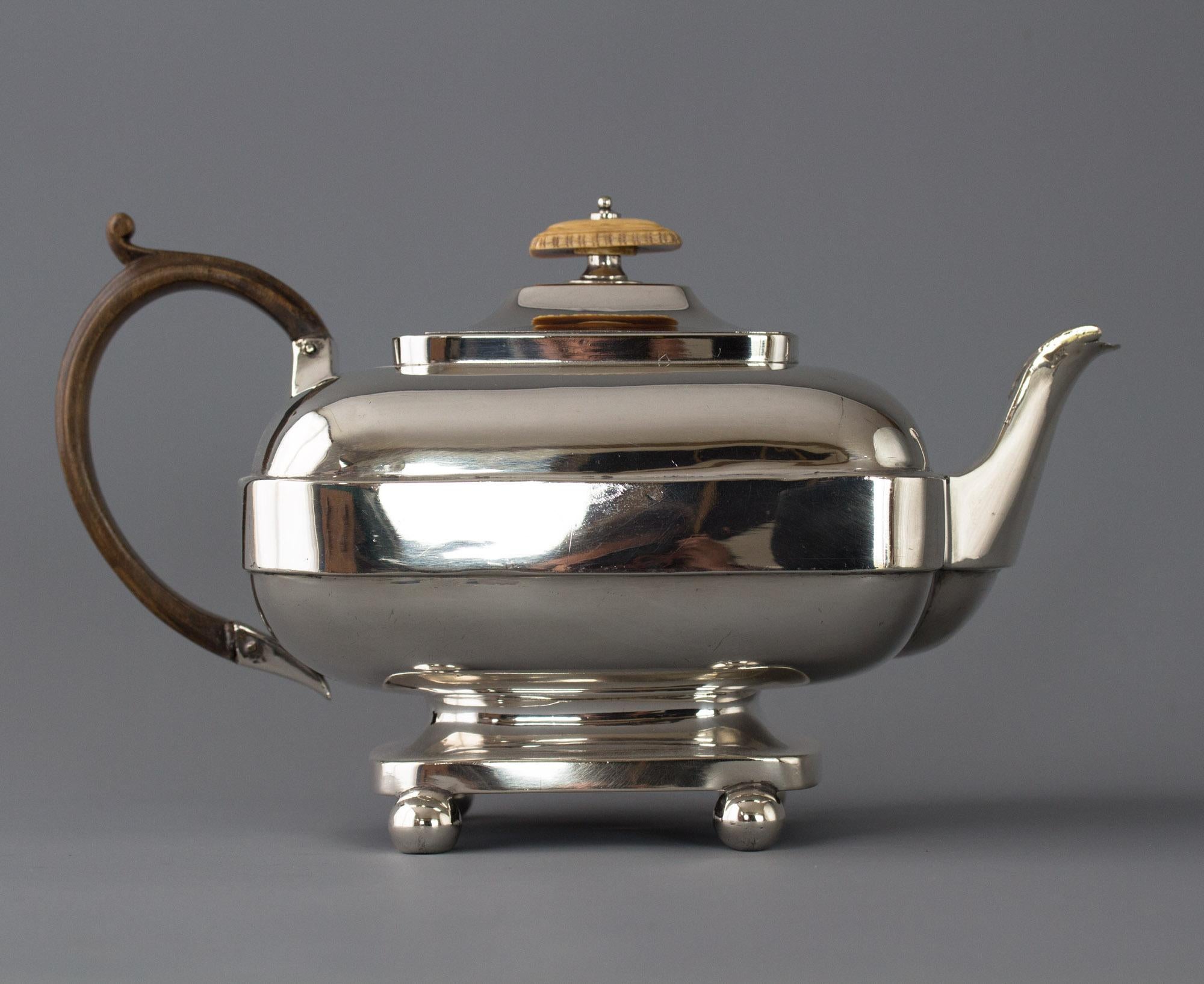 A very rare York silver George III teapot. Of oblong form with a raised band round the middle. The raised lid and finial are the same shape, a curved spout and a fruitwood handle. All standing on a pedestal on four ball feet.
Clearly hallmarked for