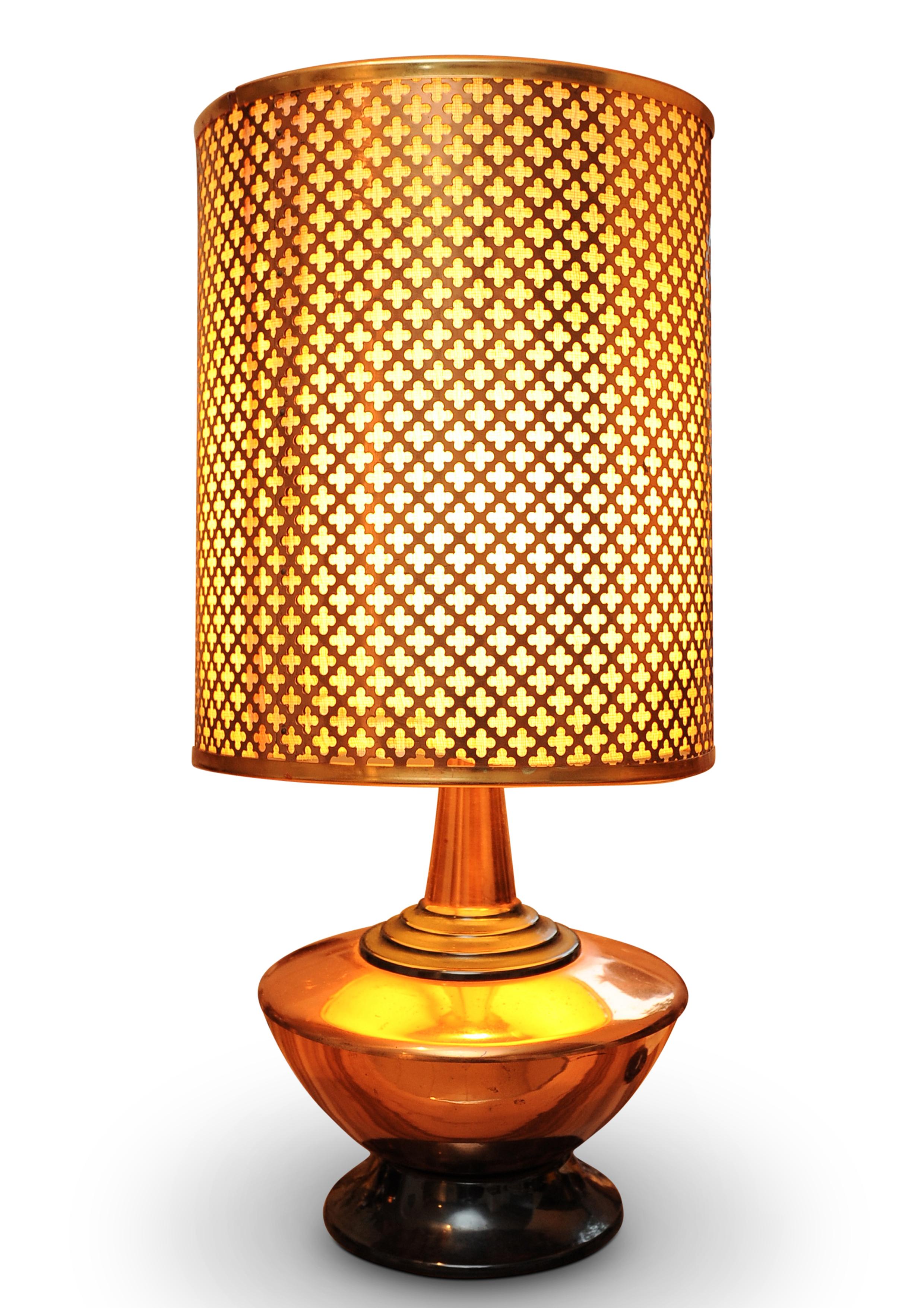 A Zambian Copper Table Lamp With A Repeating Alhambra Design Lattice Work Pattern..

Copper shade has a linen back, lamp column features on an ebonised centre.

