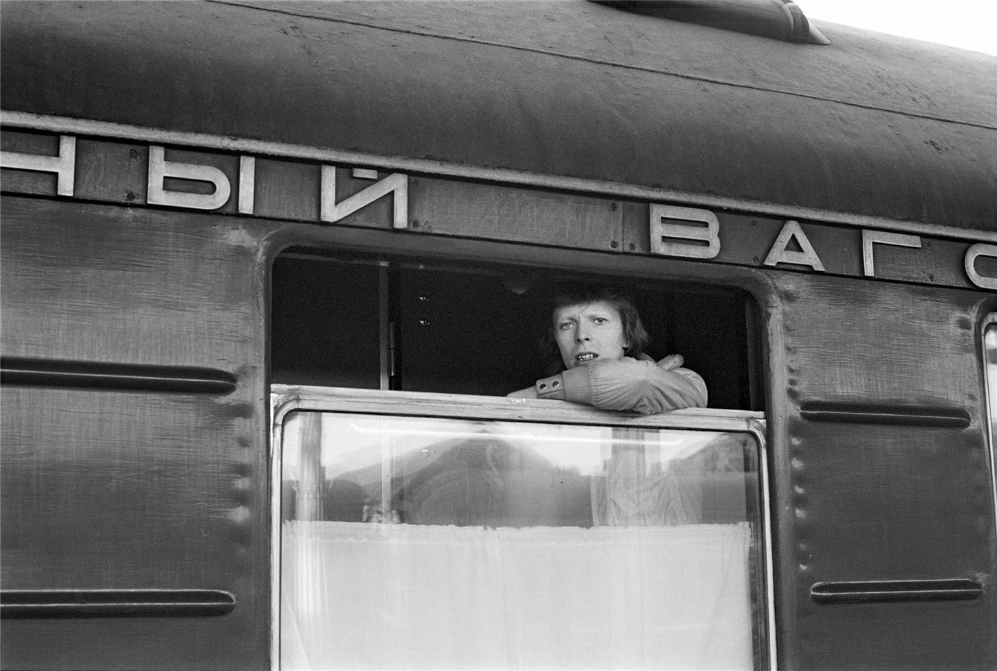 Geoff MacCormack Black and White Photograph - David Bowie, looking out of window of Trans Siberian Express, 1973