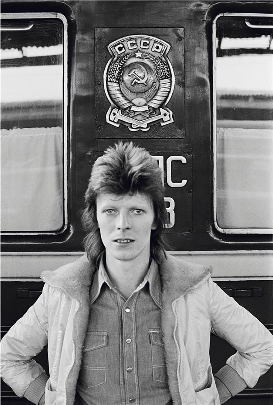 Geoff MacCormack Black and White Photograph - David Bowie, in front of Trans Siberian Express, 1973