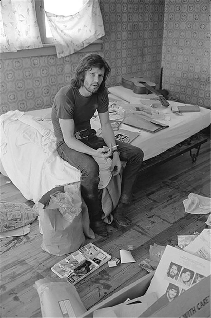 Al Clayton Black and White Photograph - Kris Kristofferson, on bed with guitar, 1970
