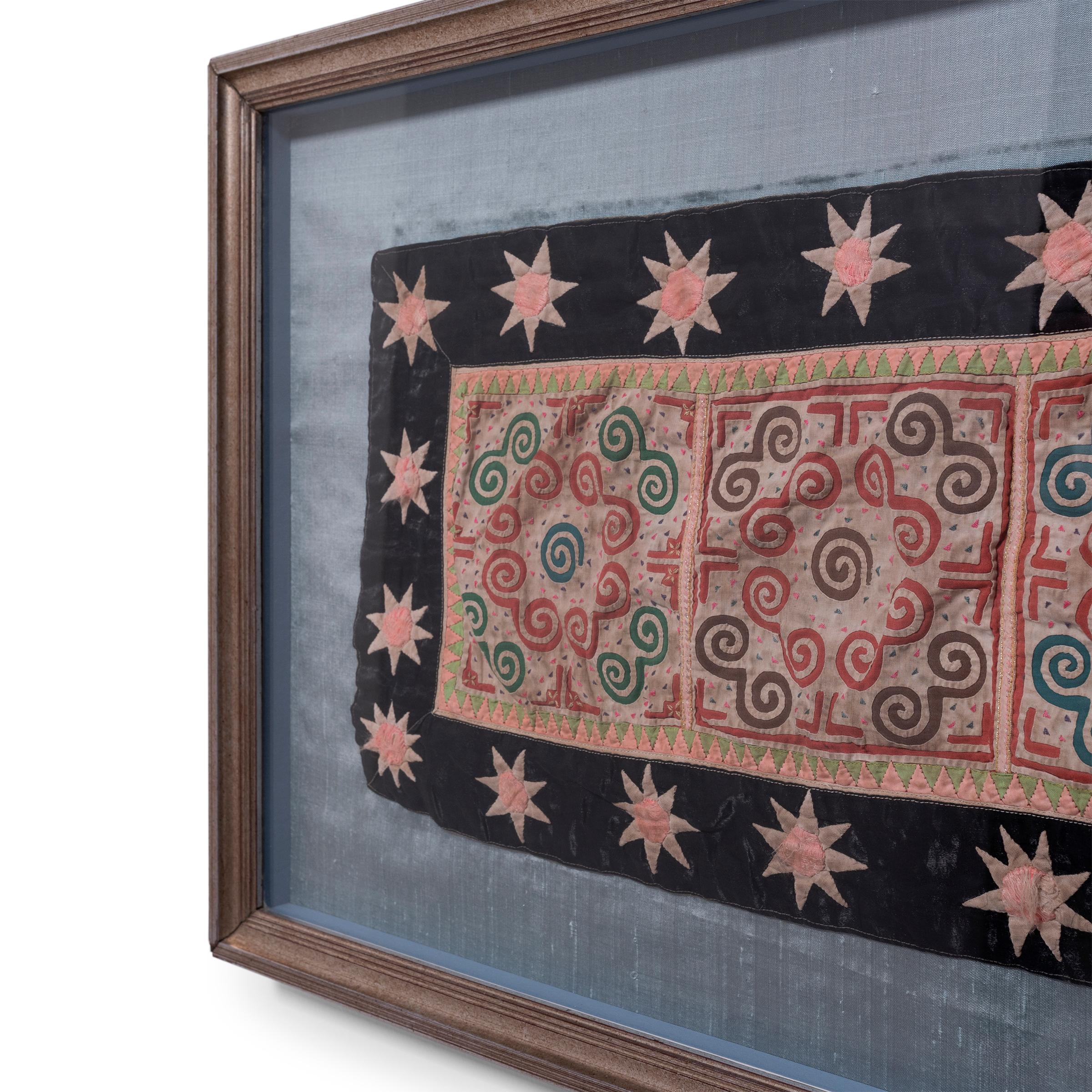 Dieses farbenfrohe Hmong-Textil aus der Mitte des 20. Jahrhunderts ist ein klassisches Beispiel für die Appliqué-Technik, die für das als paj ntaub bekannte traditionelle Tuch verwendet wird. Beim Applizieren werden Stoffstücke auf ein anderes Stück