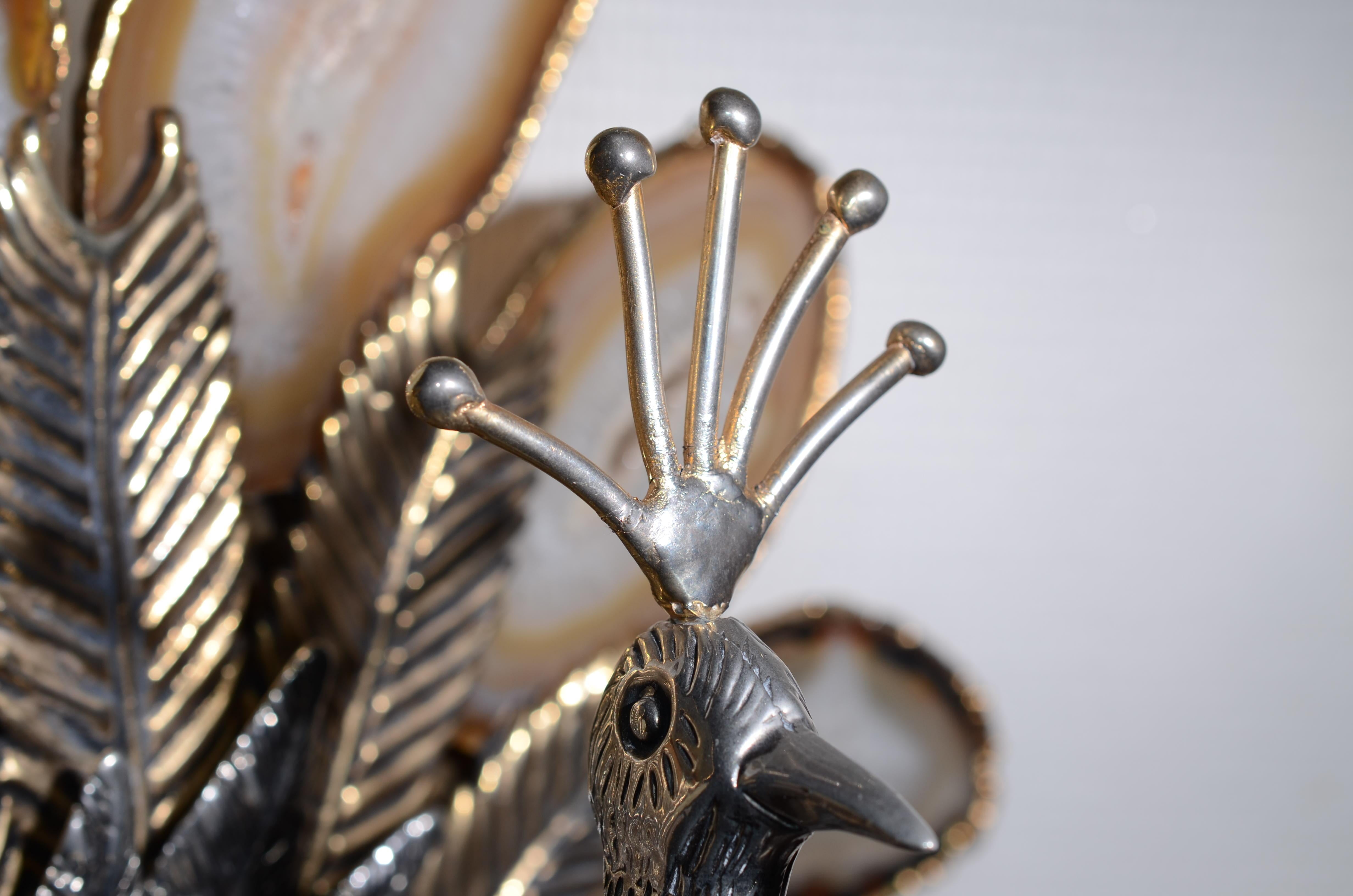 This amazing sculpture figures a peacock making the wheel.  Each feather is made of a slice of transparent agate, soldered with brass to the rest of the wheel.  The agate wheel is melded on a wheel of brass feathers, and maintained on the back with