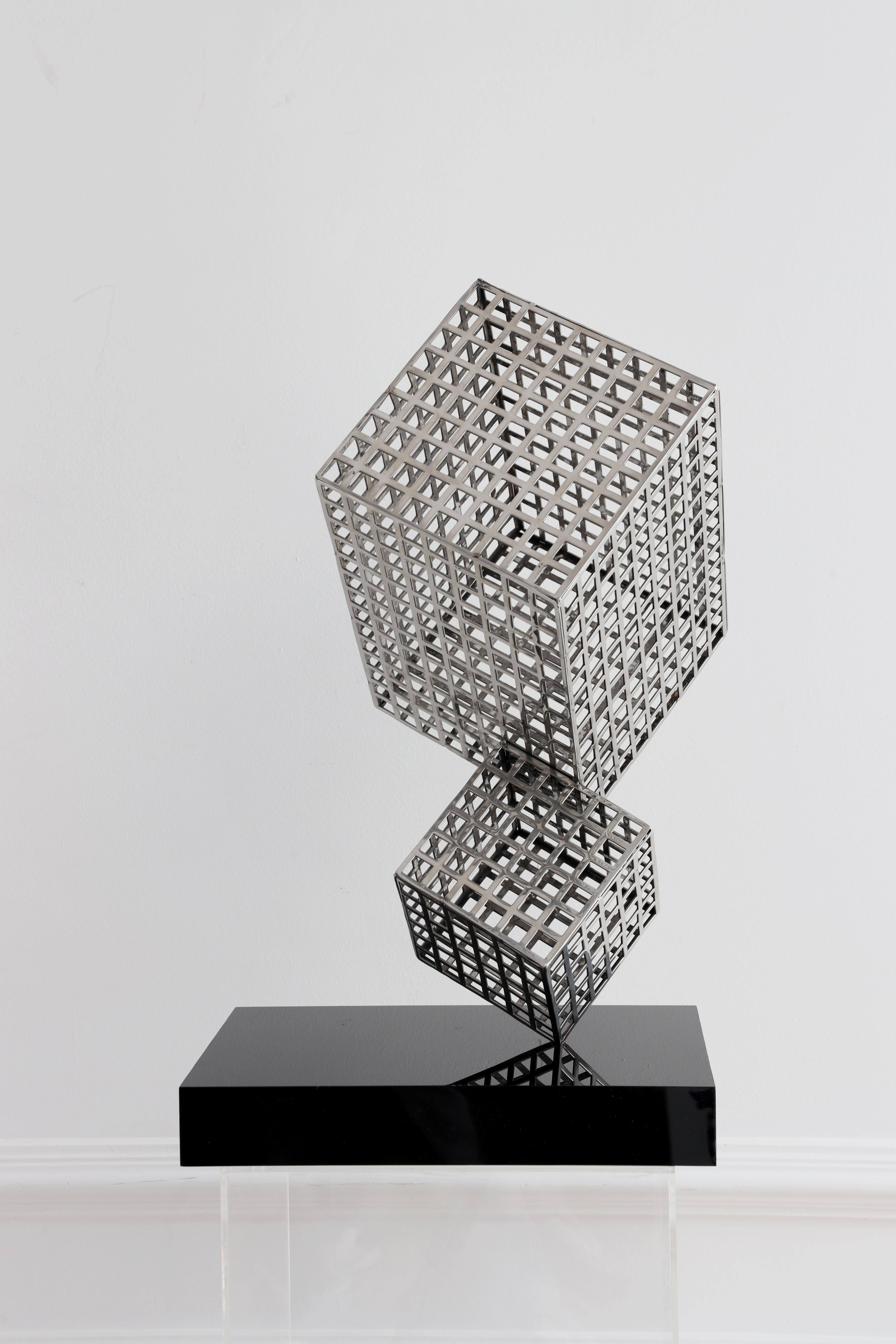 Two moving cubes on harmony through the air. Steel sculpture with perforated cubes