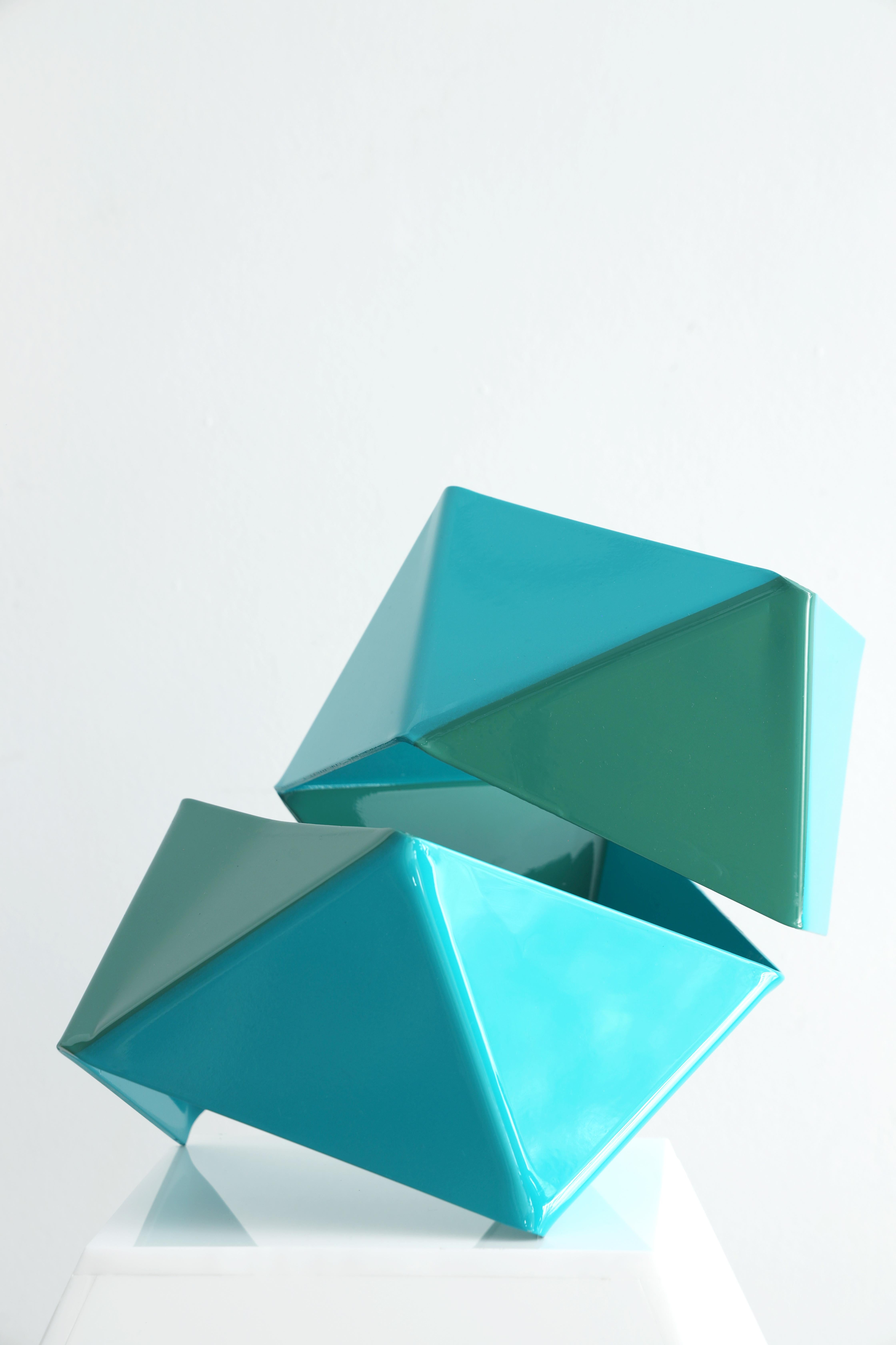 Blue and green bow tie sculpture. The sculpture is breaking in air.