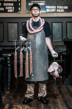 Butcher by Can Turkyilmaz. Photograph of butcher with sausages and pigs head