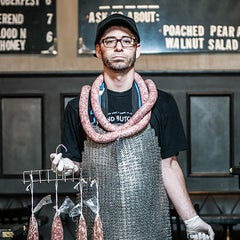 Butcher by Can Turkyilmaz. Photograph of butcher with sausages and pigs head