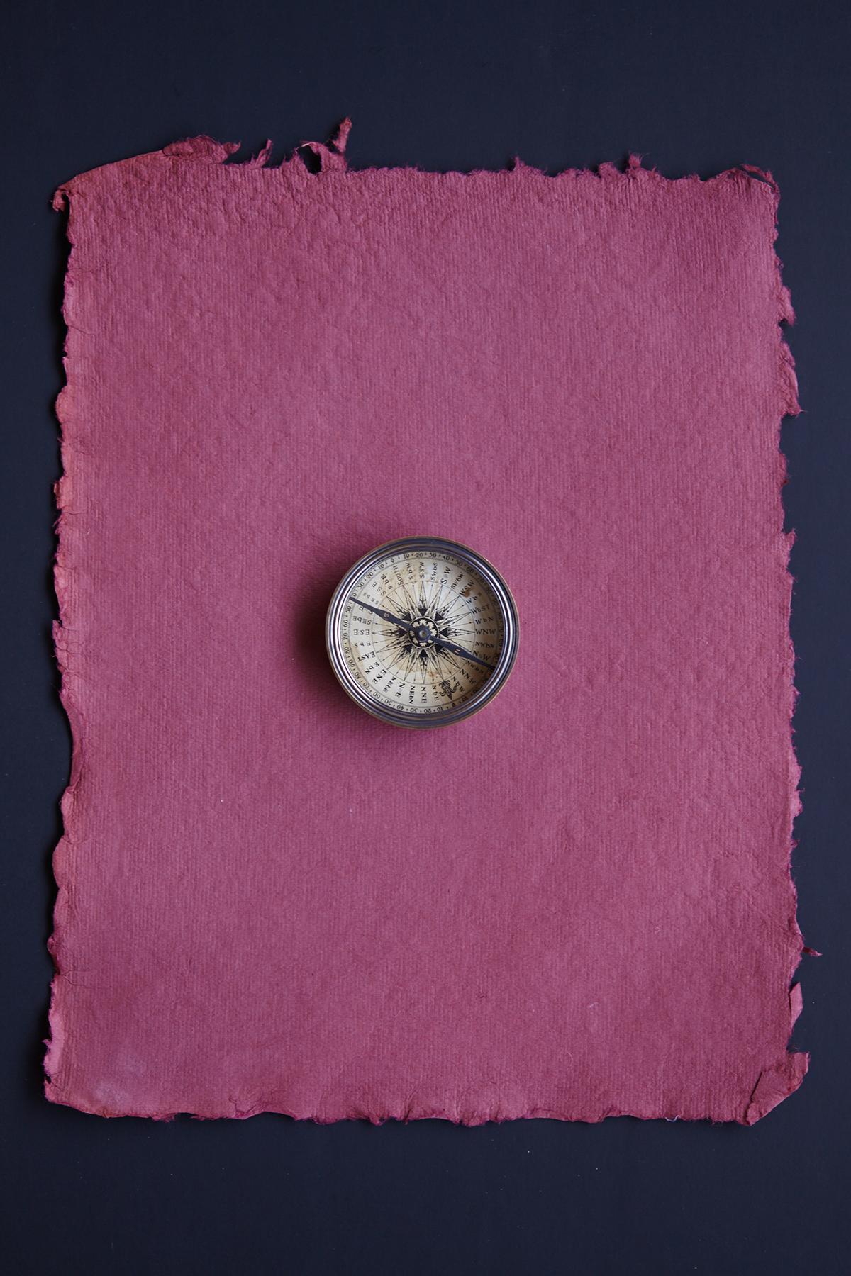 Caren Alpert photograph of a vintage compass on a maroon paper background. “Compass #2” is printed on archival, full color photographic paper. This size is 11” x 14”. Available in three sizes (unframed): 11” x 14”, 16” x 20”, 24” x 36”. Custom sizes