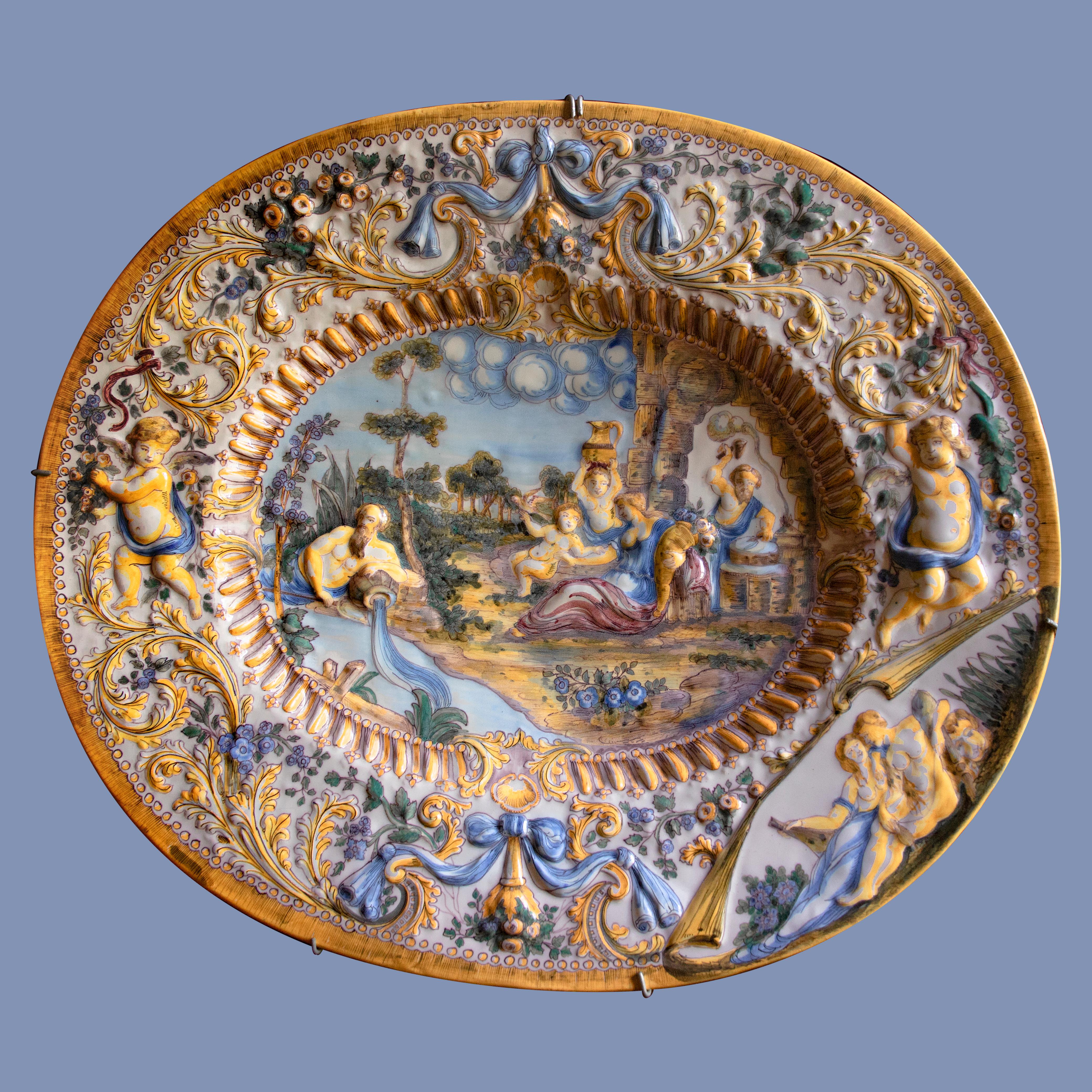 Oval Italian ceramic dish adorned with baroque figures and decoration in relief For Sale 1