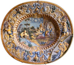 Oval Italian ceramic dish adorned with baroque figures and decoration in relief