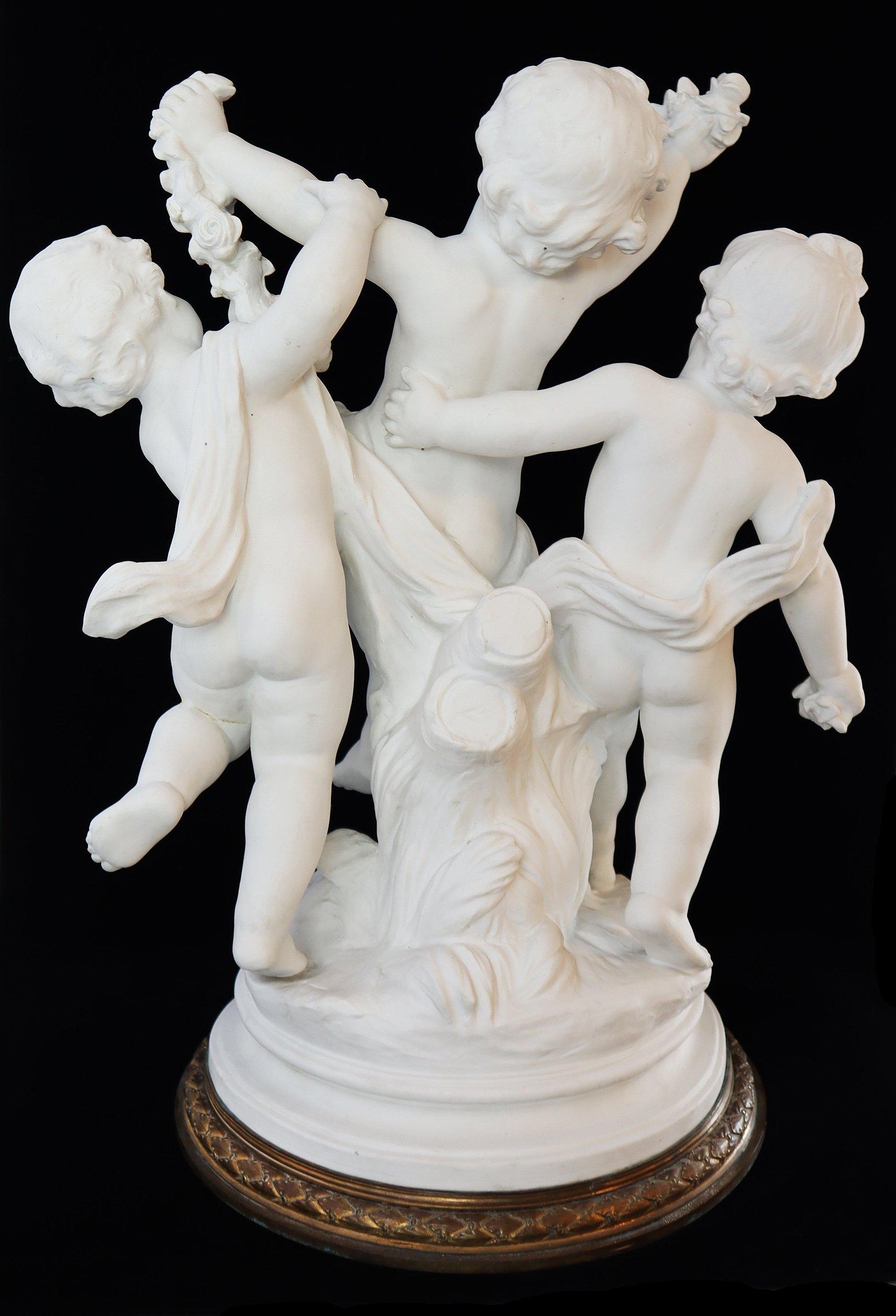 A 19th century French sculpture depicting a group of three putti dancing and playing with flower garlands (Louis XV style), placed on a round gilded bronze base, adorned with a fret of laurel leaves. Modeled after Ferdinando Vichy (1875-1945).