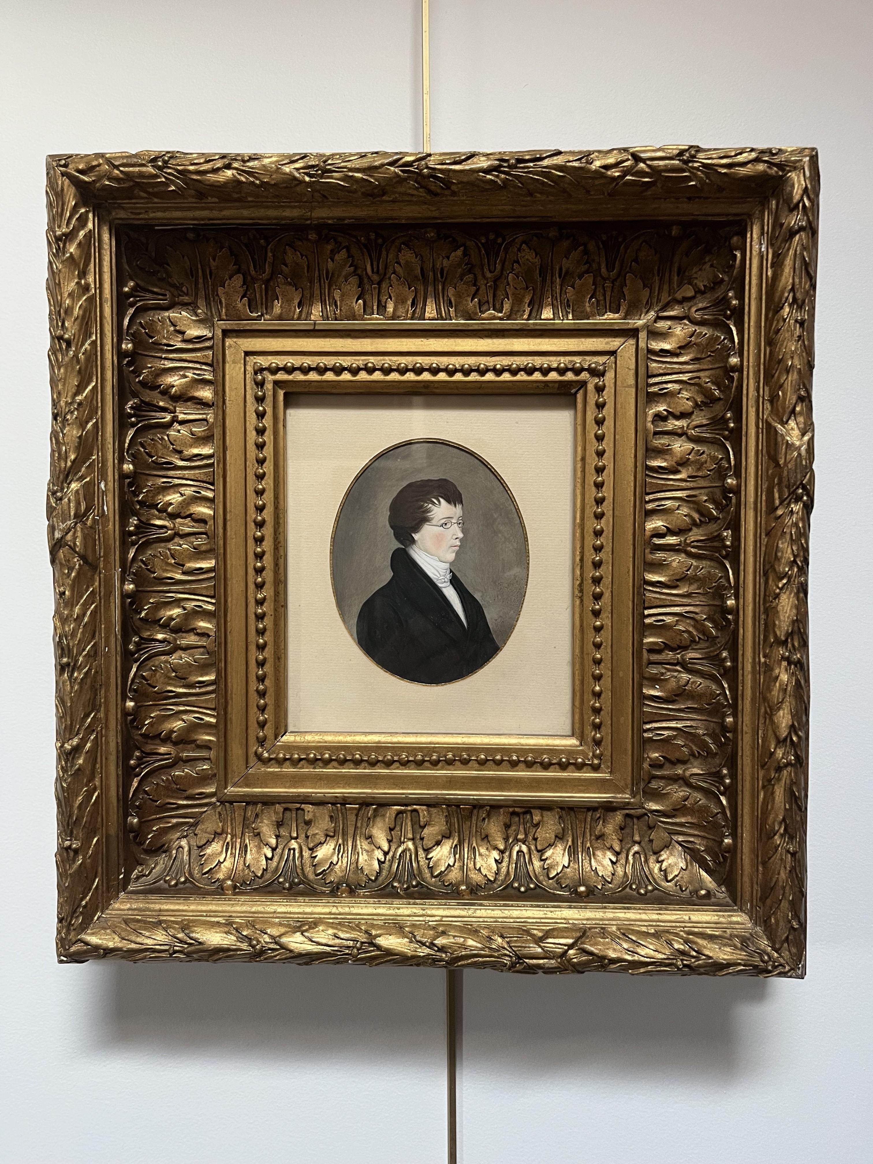 Anfang des 19. Jahrhunderts, 
Porträt eines jungen Mannes mit Brille, 
Gouache auf Papier
13 x 10,5 cm ovale Ansicht
In einem Vintage-Rahmen  :  41,5 x 39 cm, Unfälle und Mängel in der Vergoldung, aber größtenteils nicht sichtbar von vorne (siehe