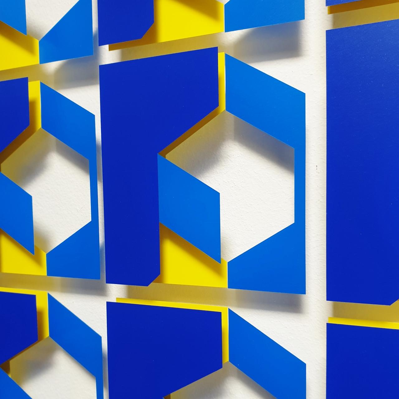 Relief MG902 is a medium size contemporary modern abstract geometric wall relief by Dutch visual artist Let de Kok. This relief consists of two interspaced panels of museum glass with a multi-layer geometric pattern cut from uv-resistant polymeric