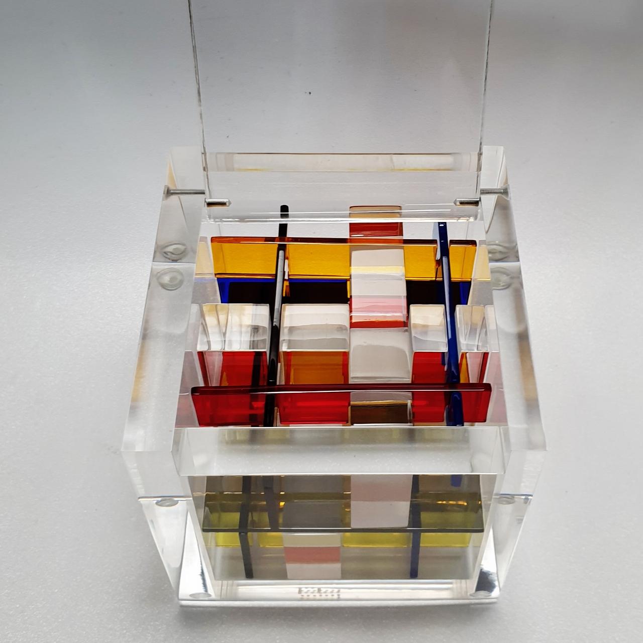 Homage to Rietveld is a unique small size contemporary modern cube sculpture by the famous Dutch artist couple Nel Haringa and Fred Olijve. The cube sculpture consists of a few dozen hand cut hand polished plexiglass elements carefully stacked