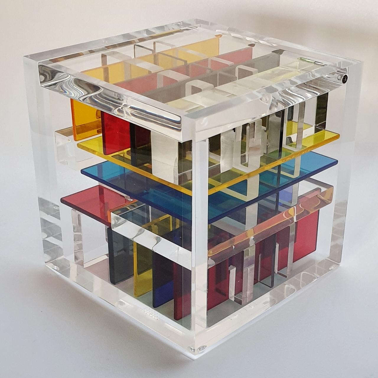 New York City is a unique small size contemporary modern cube sculpture by the famous Dutch artist couple Nel Haringa and Fred Olijve. The cube sculpture consists of a few dozen hand cut hand polished plexiglass elements carefully stacked together