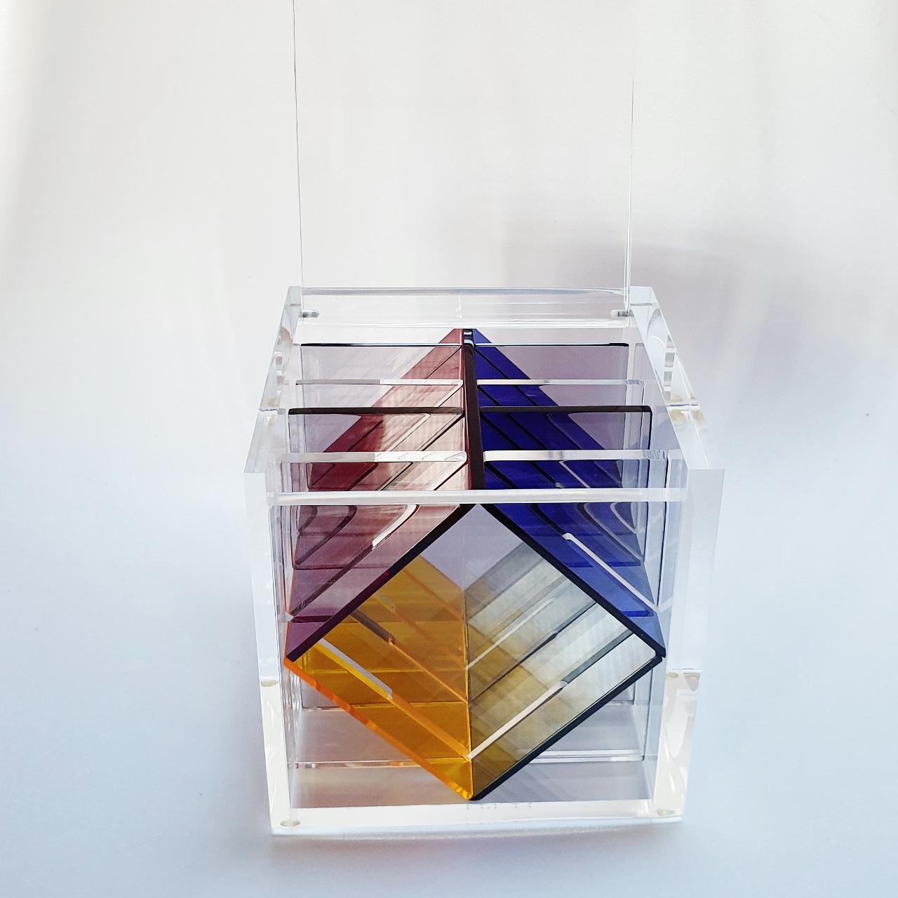 Homage to Van Doesburg is a unique small size contemporary modern cube sculpture by the famous Dutch artist couple Nel Haringa and Fred Olijve. The cube sculpture consists of only eight hand cut hand polished plexiglass elements carefully stacked