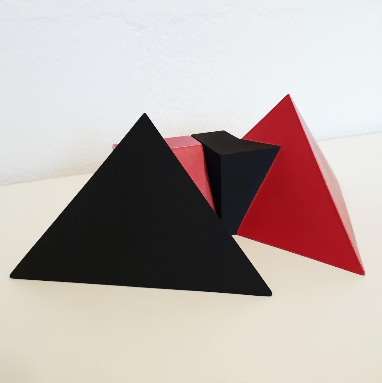 Sculpture SC1502 (red) is a contemporary modern abstract geometric object sculpture by Dutch visual artist Let de Kok. 
This sculpture consists of two ceramic elements, the red surface has a smooth finish and the black surface is textured and rough