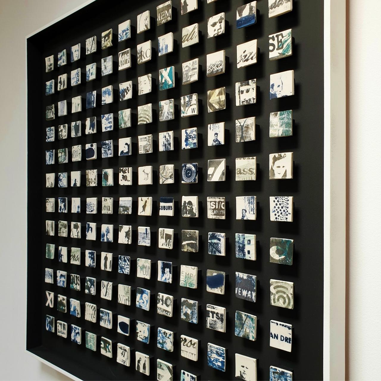 Monday blues is a unique contemporary modern wall object by British artist Kate Brett. This one of a kind object consists of  144 handmade unglazed porcelain elements mounted in a hand painted matt black frame with a white raised edge. At the rear