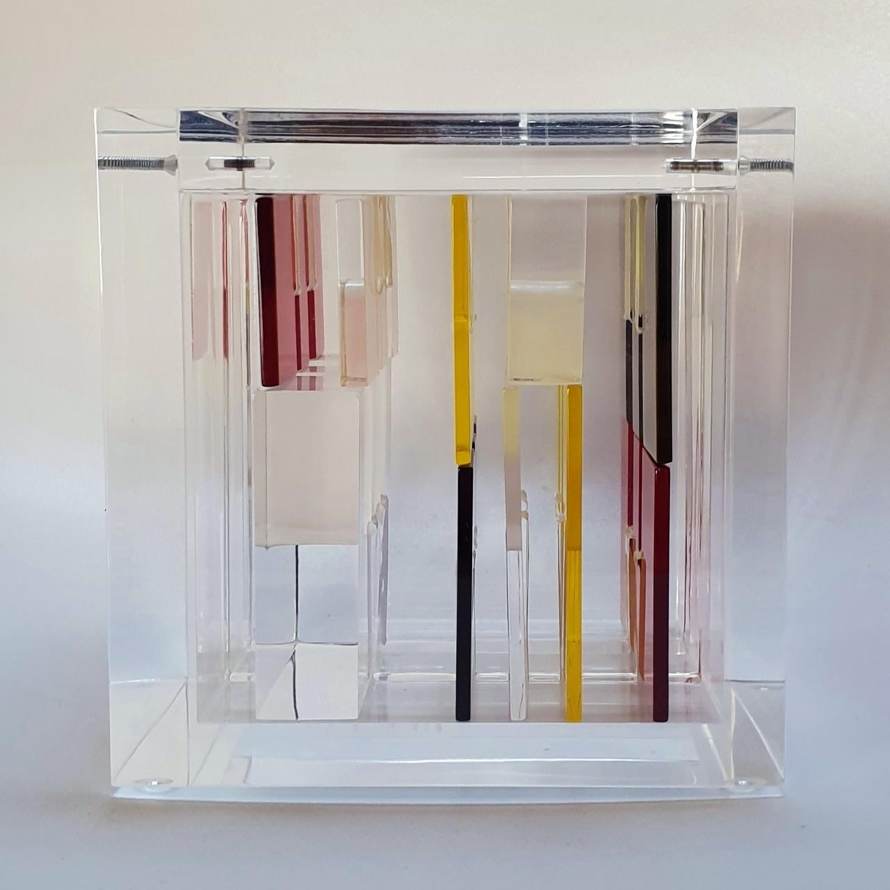 Homage to Mondriaan is a unique small size contemporary modern cube sculpture by the famous Dutch artist couple Nel Haringa and Fred Olijve. The cube sculpture consists of a dozen hand cut hand polished plexiglass elements carefully stacked together