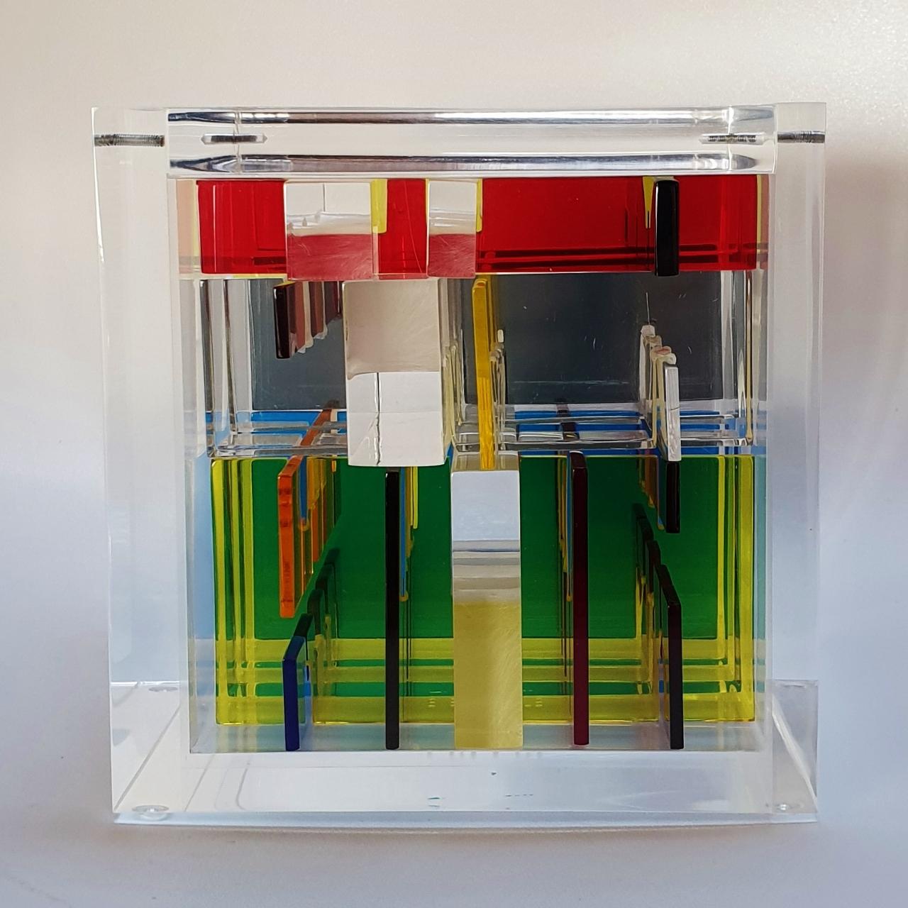Homage to Mondriaan is a unique small size contemporary modern cube sculpture by the famous Dutch artist couple Nel Haringa and Fred Olijve. The cube sculpture consists of a few dozen hand cut hand polished plexiglass elements carefully stacked