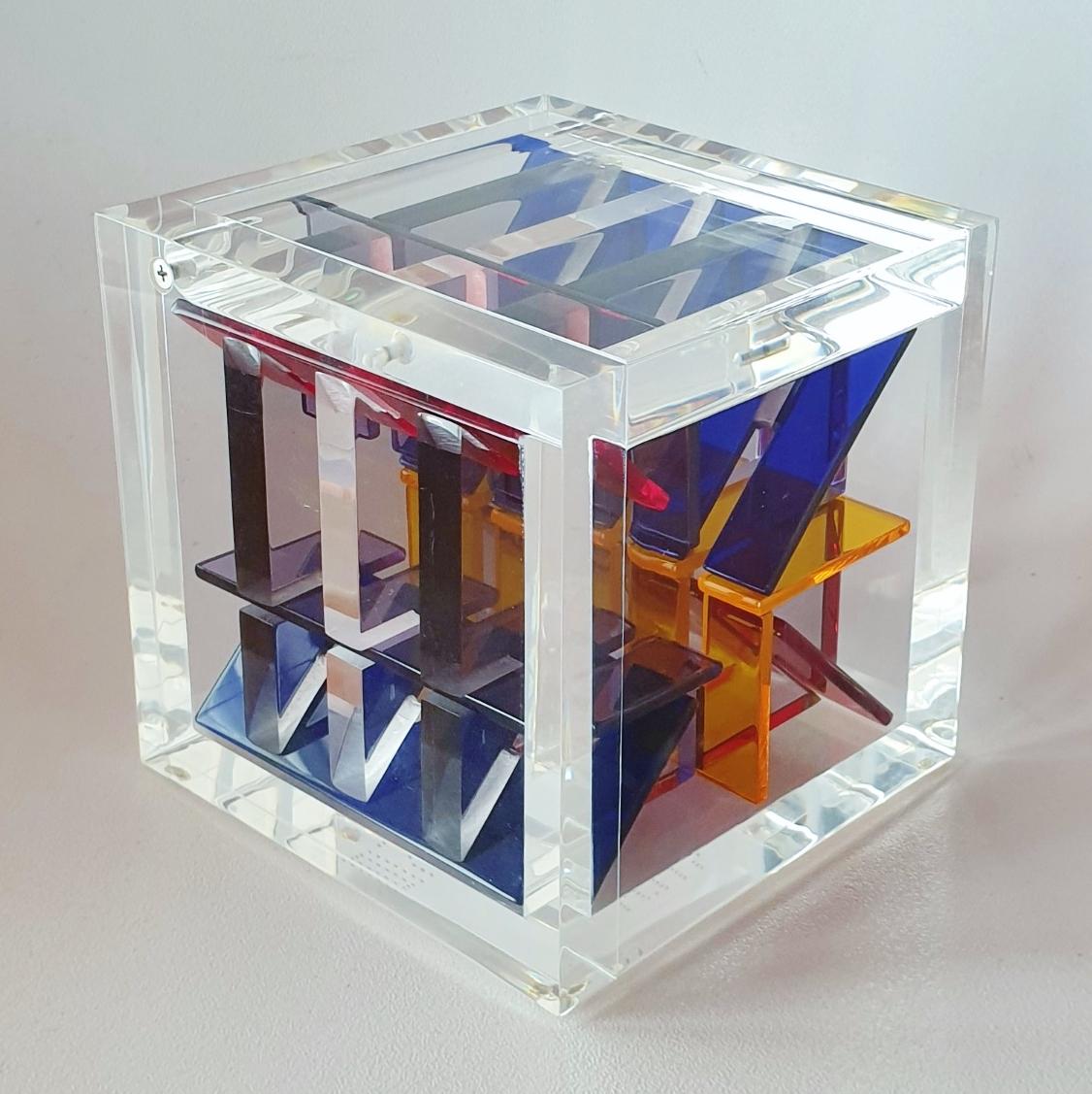 Homage to Van Doesburg is a unique small size contemporary modern cube sculpture by the famous Dutch artist couple Nel Haringa and Fred Olijve. The cube sculpture consists of a dozen hand cut hand polished plexiglass elements carefully stacked