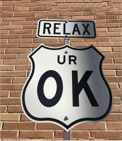 „“Relax UR OK““ – zeitgenössische Straßenschild-Skulptur