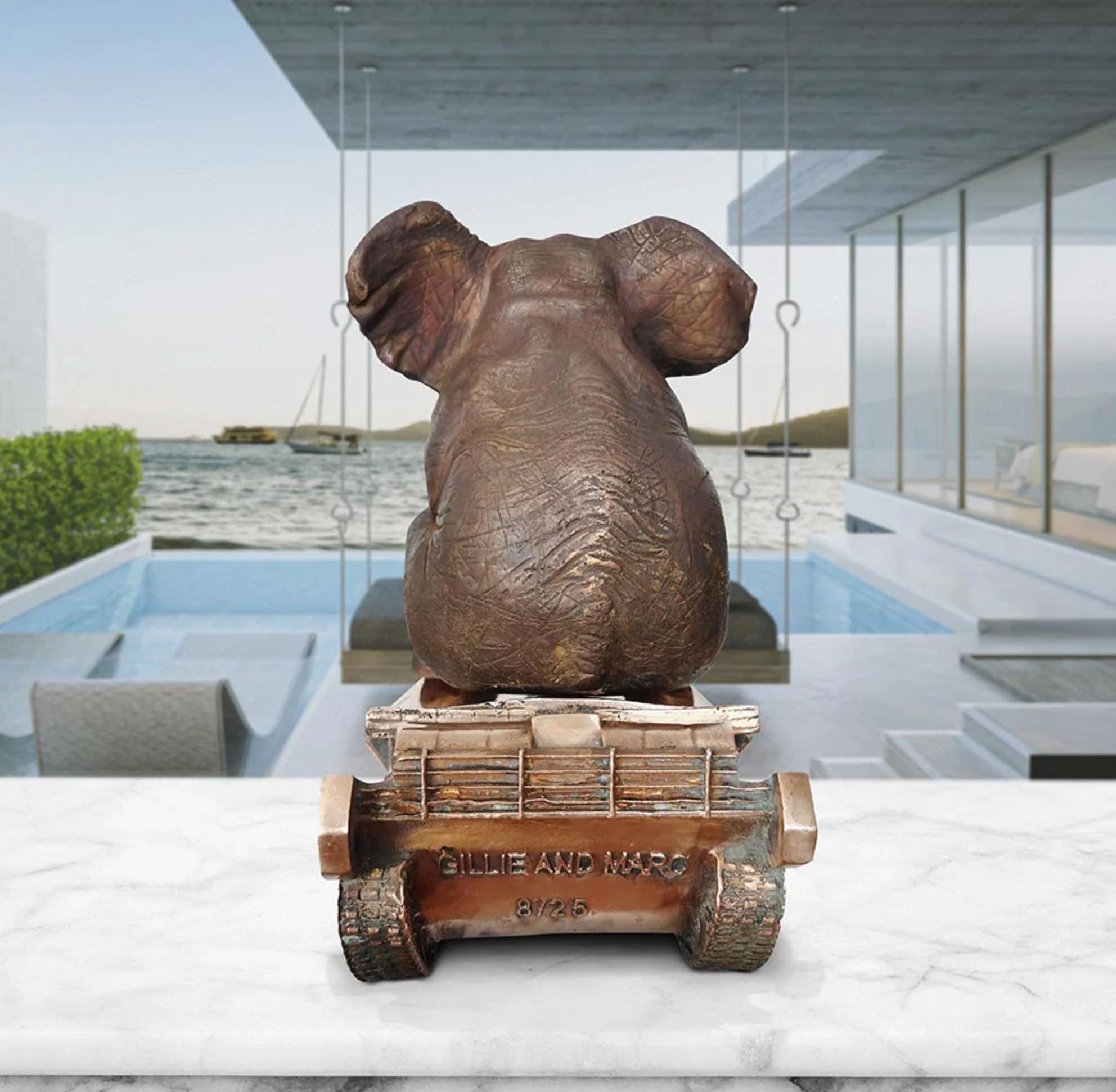 Title: The elephant has a crush on tanks
Authentic bronze sculpture

This authentic bronze sculpture titled 'The elephant has a crush on tanks' by artists Gillie and Marc has been meticulously crafted in bronze. It features an elephant sitting on a