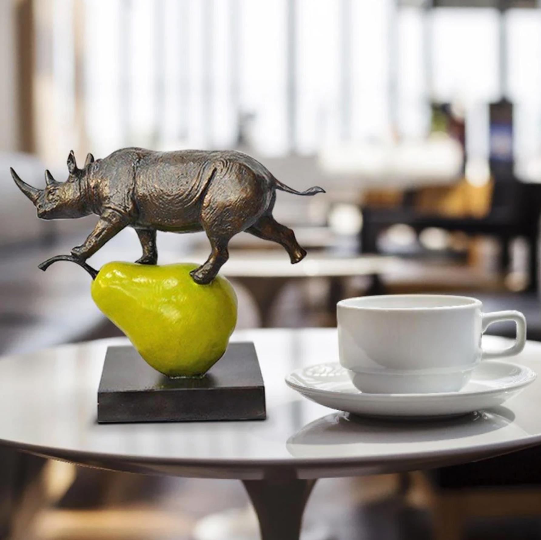 Title: The rhino was just pearfect
Authentic Small Bronze Sculpture

This authentic bronze sculpture titled 'The rhino was just pearfect' by artists Gillie and Marc has been meticulously crafted in bronze. This sculpture features a rhino standing on