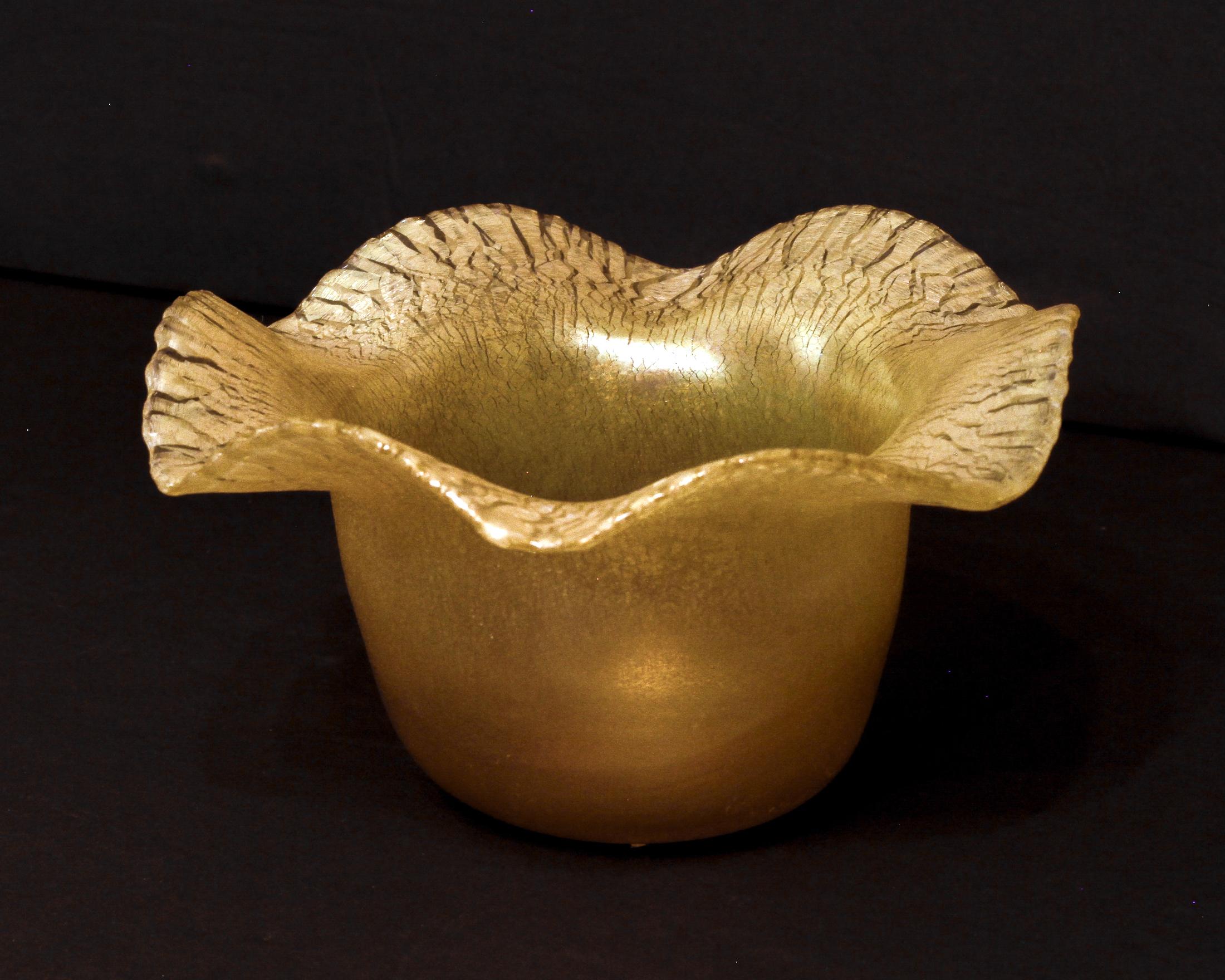 A delicate gold iridescent favrile art glass bowl by Tiffany and Co., featuring a flared and ruffled mouth. 
Height: 3.25 in
Diameter: approx. 5.5 in.
