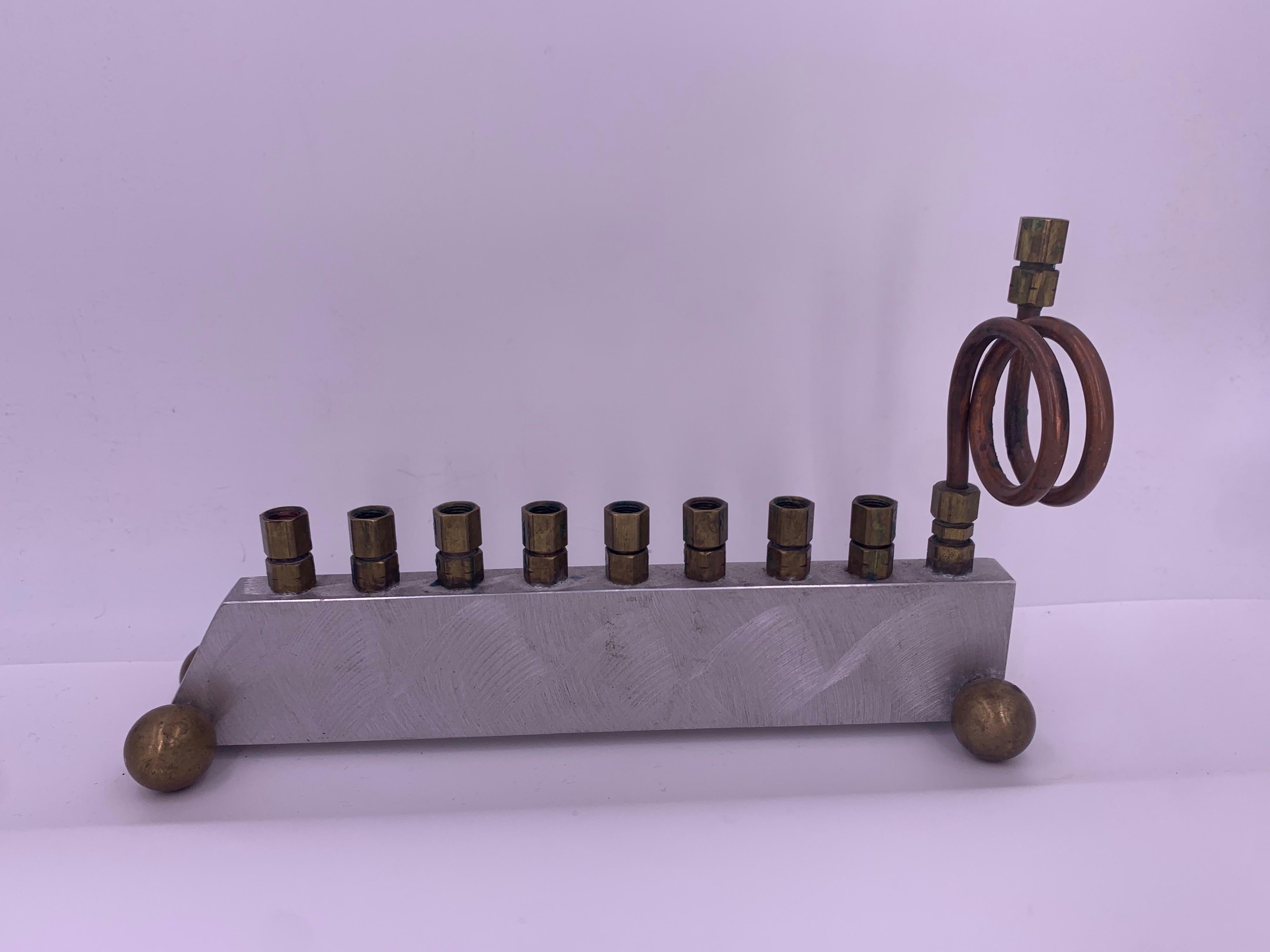 Aluminum and brass Menorah, with a beautiful sculptural appeal. We like how function evolves into art with this piece. A great conversation piece and one that will be appreciated well-beyond the Holidays.